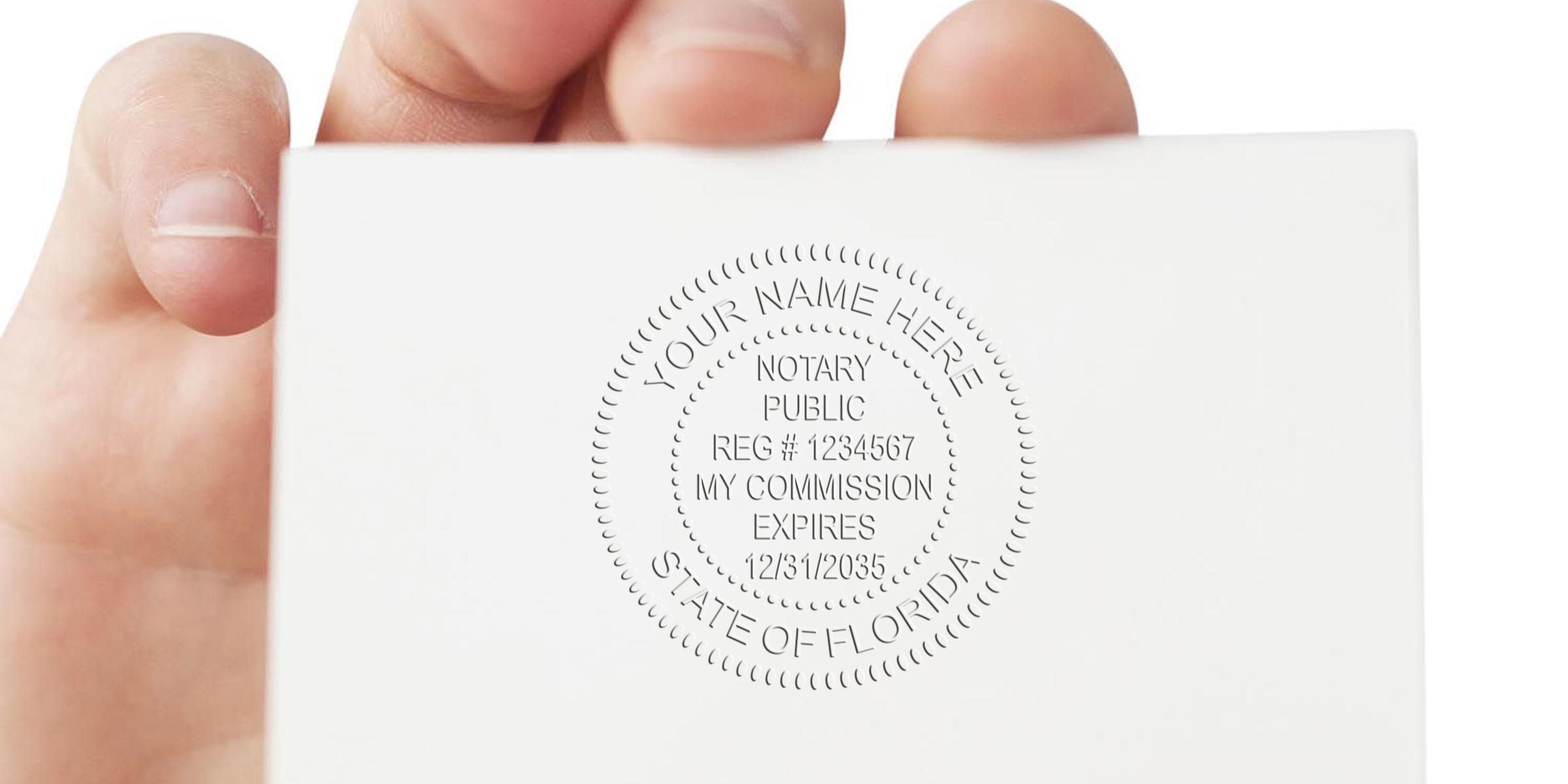 Hand holding a Florida notary embossing seal showing commission expiration date, meeting Florida notary stamp requirements.