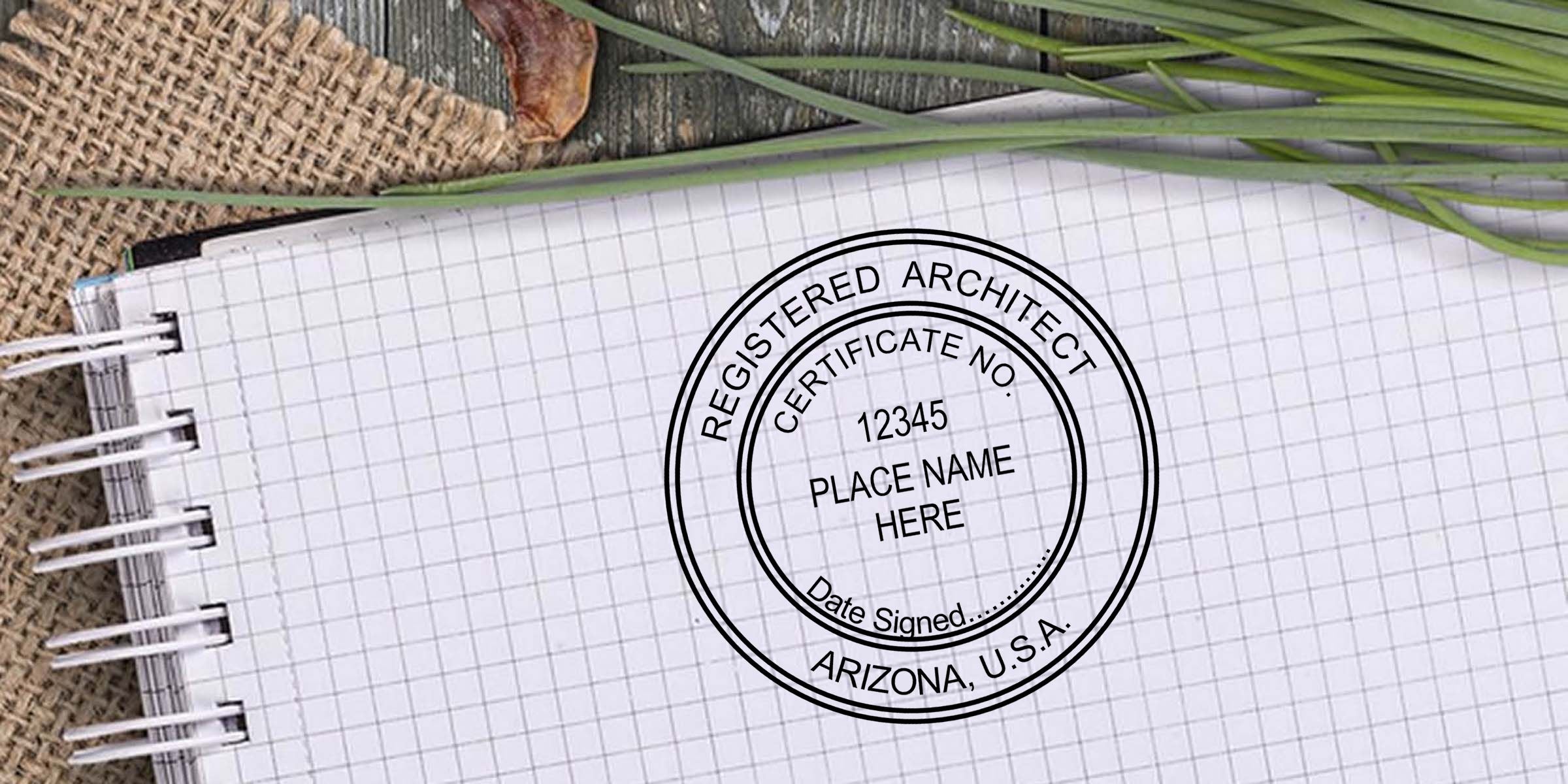 Registered architect certification stamp on graph paper notebook with Arizona, U.S.A. seal, certificate number, and tropical leaves on a rustic desk