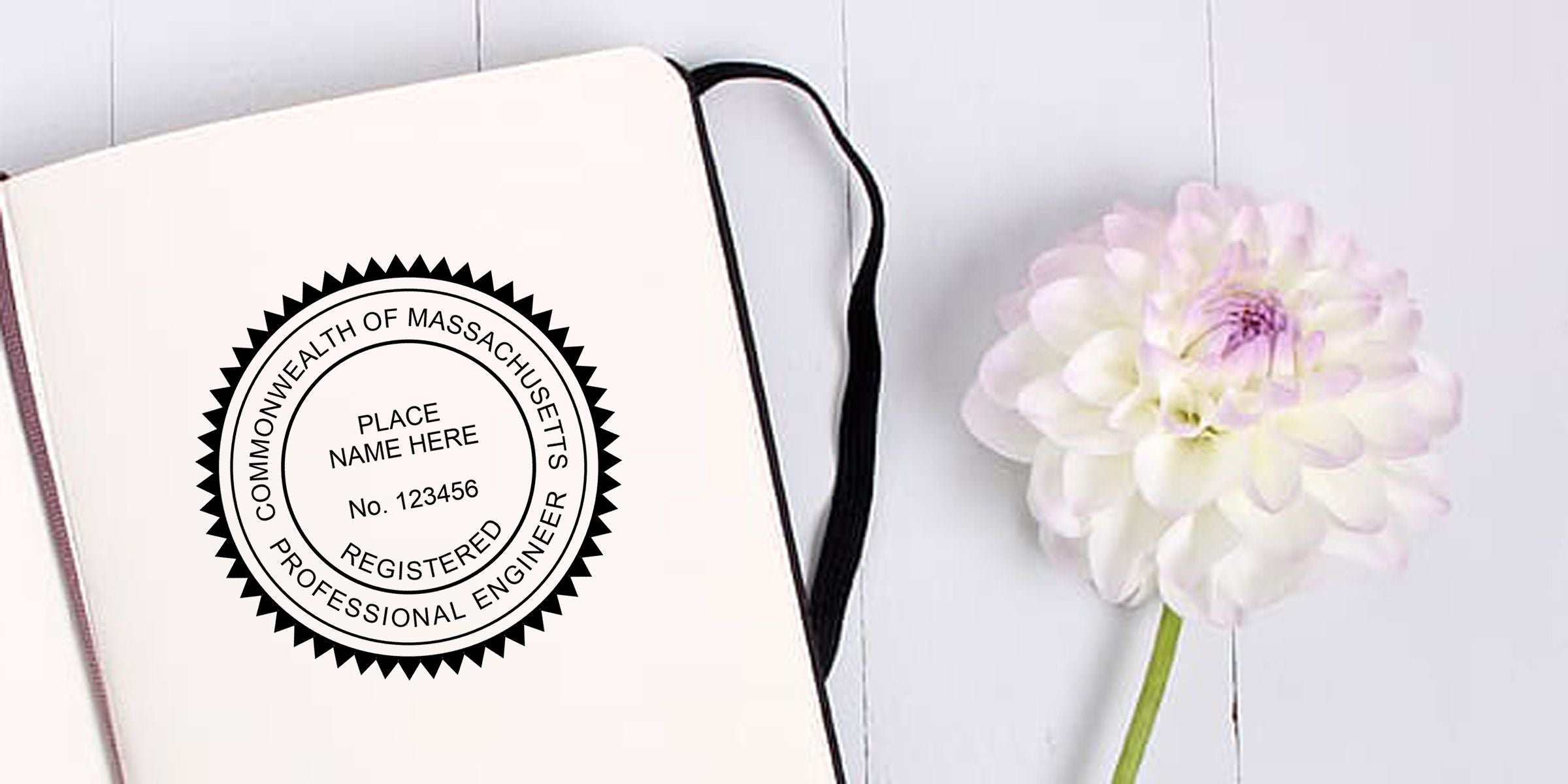 Notebook featuring a Commonwealth of Massachusetts registered professional engineer seal beside a white and pink dahlia flower