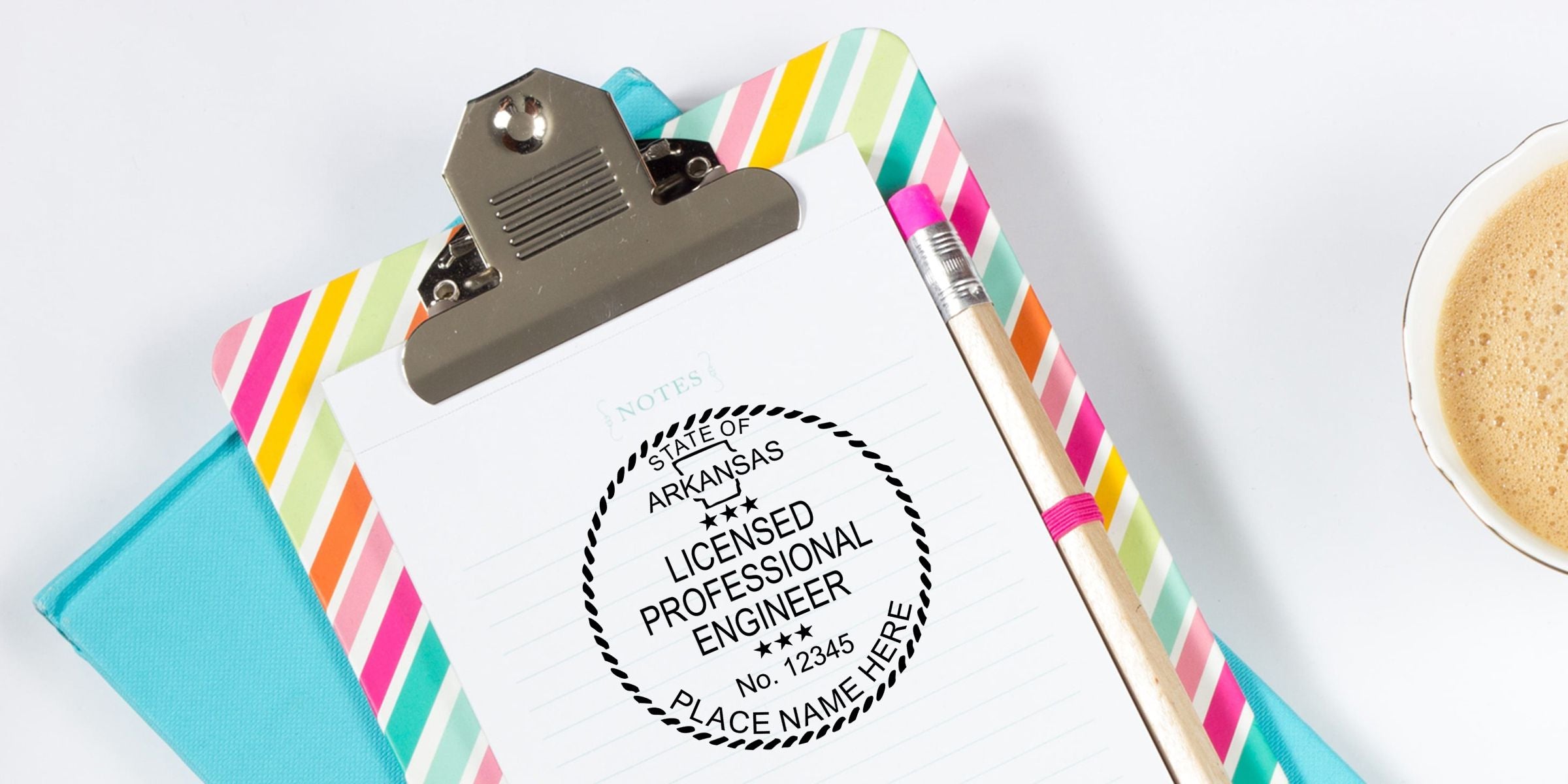 Arkansas licensed professional engineer stamp on clipboard with pencil and coffee cup on white desk