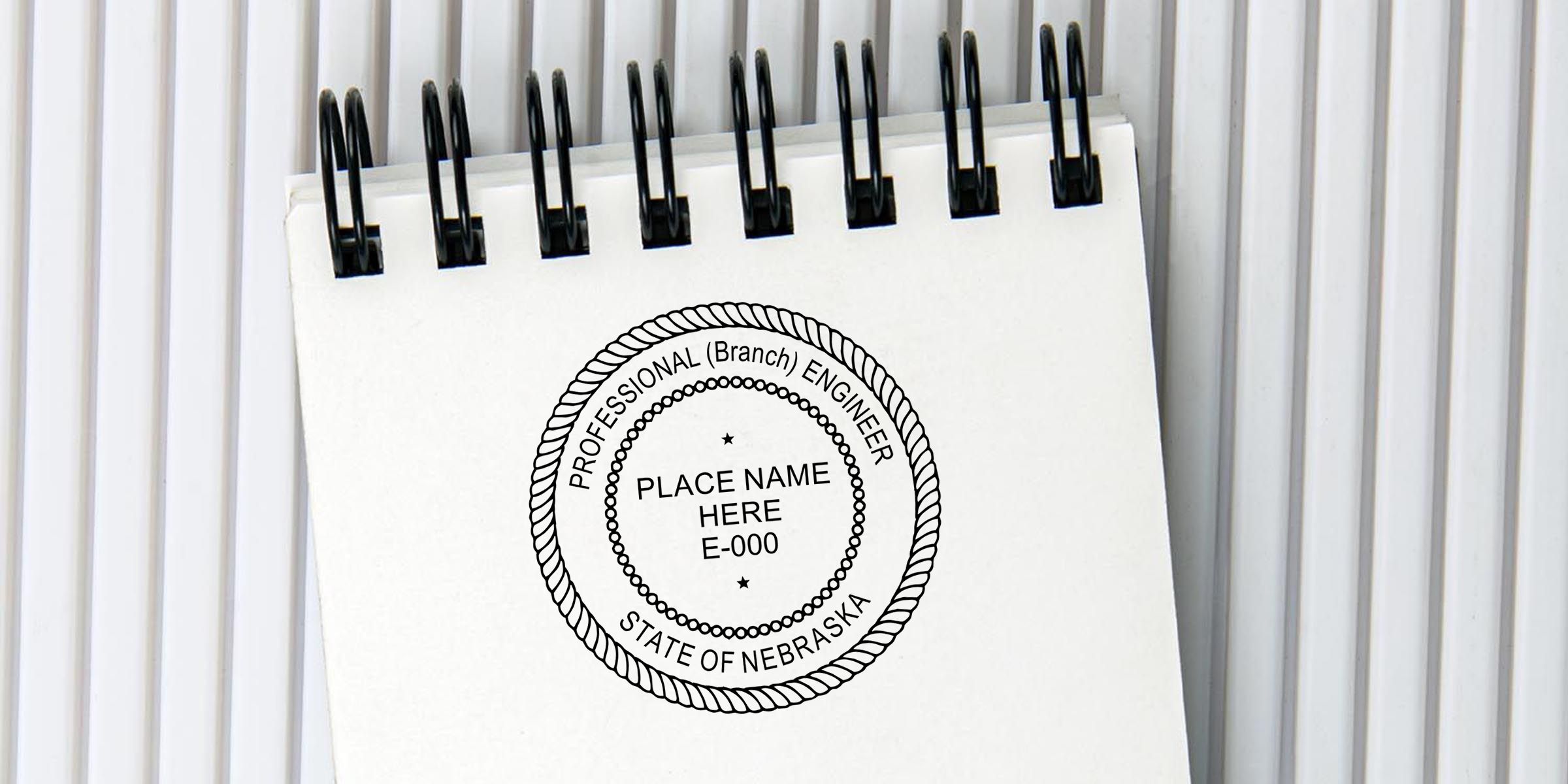 Spiral notebook with a Nebraska Professional Engineer seal design and placeholder text reading Place Name Here E-000 on a white cover