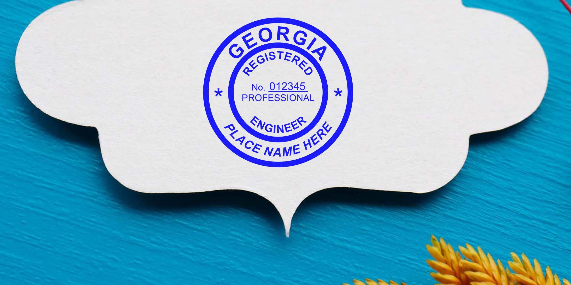 Georgia PE stamp template with a professional engineer stamp on white speech bubble paper, placed on a blue wooden background with yellow wheat stalks.