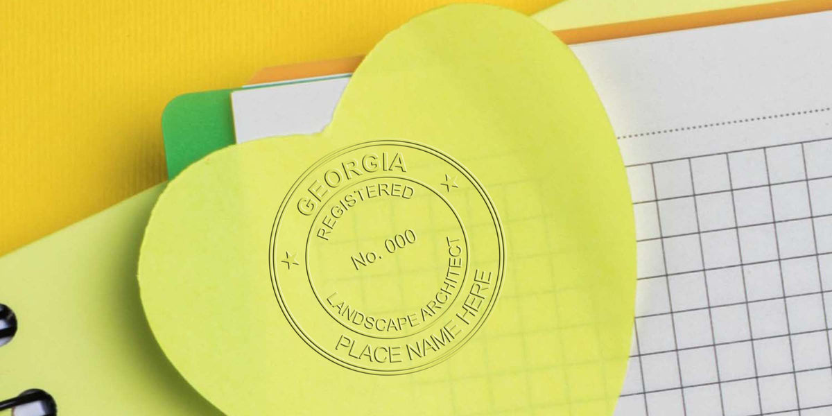 Yellow heart-shaped sticky note on graph paper notebook with colorful folders and spiral binding on yellow background, showing Georgia landscape architect seal and certification.