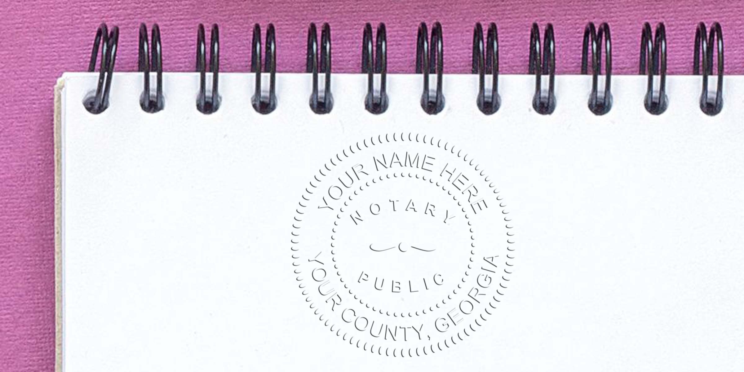 Notary public stamp on white notebook with pink background, Georgia notary supplies for smooth signing, official notary seal for county documents.