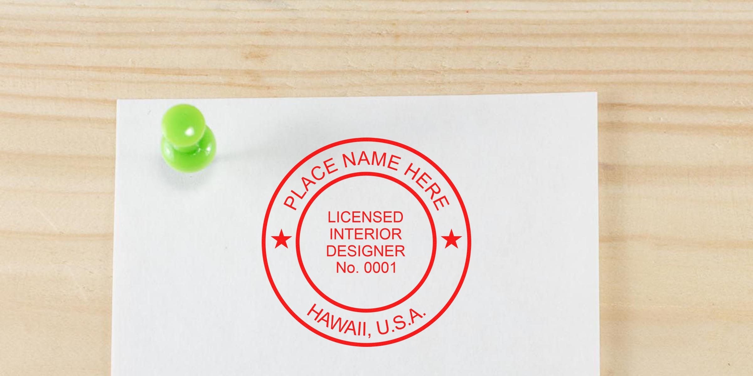 Licensed Hawaii interior designer stamp on white paper pinned with green pushpin on wooden surface, showing interior design license.