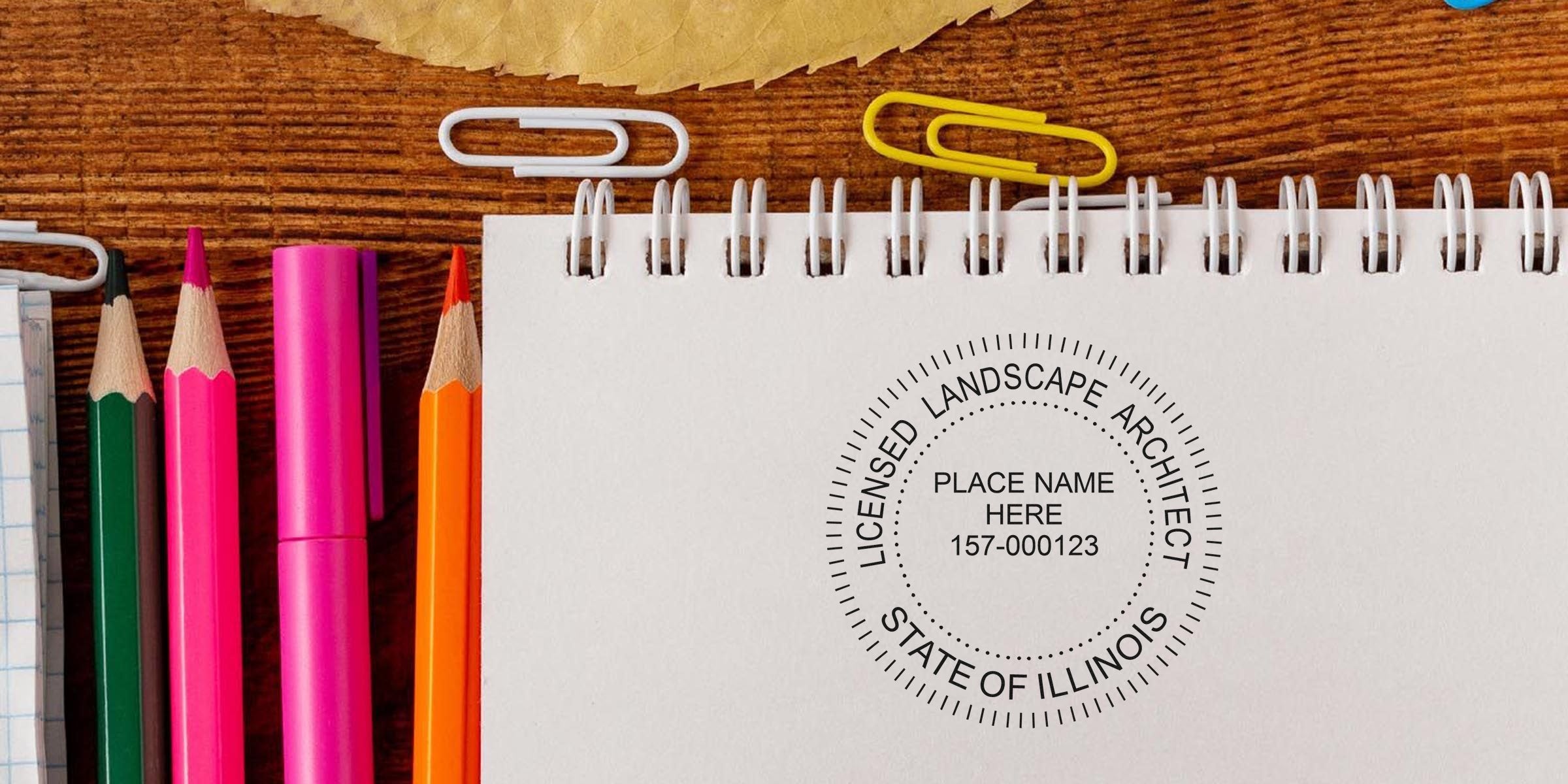 Illinois landscape architect seal on white notebook, surrounded by colorful pencils and paper clips on wooden desk, emphasizing Illinois landscape architect regulations.