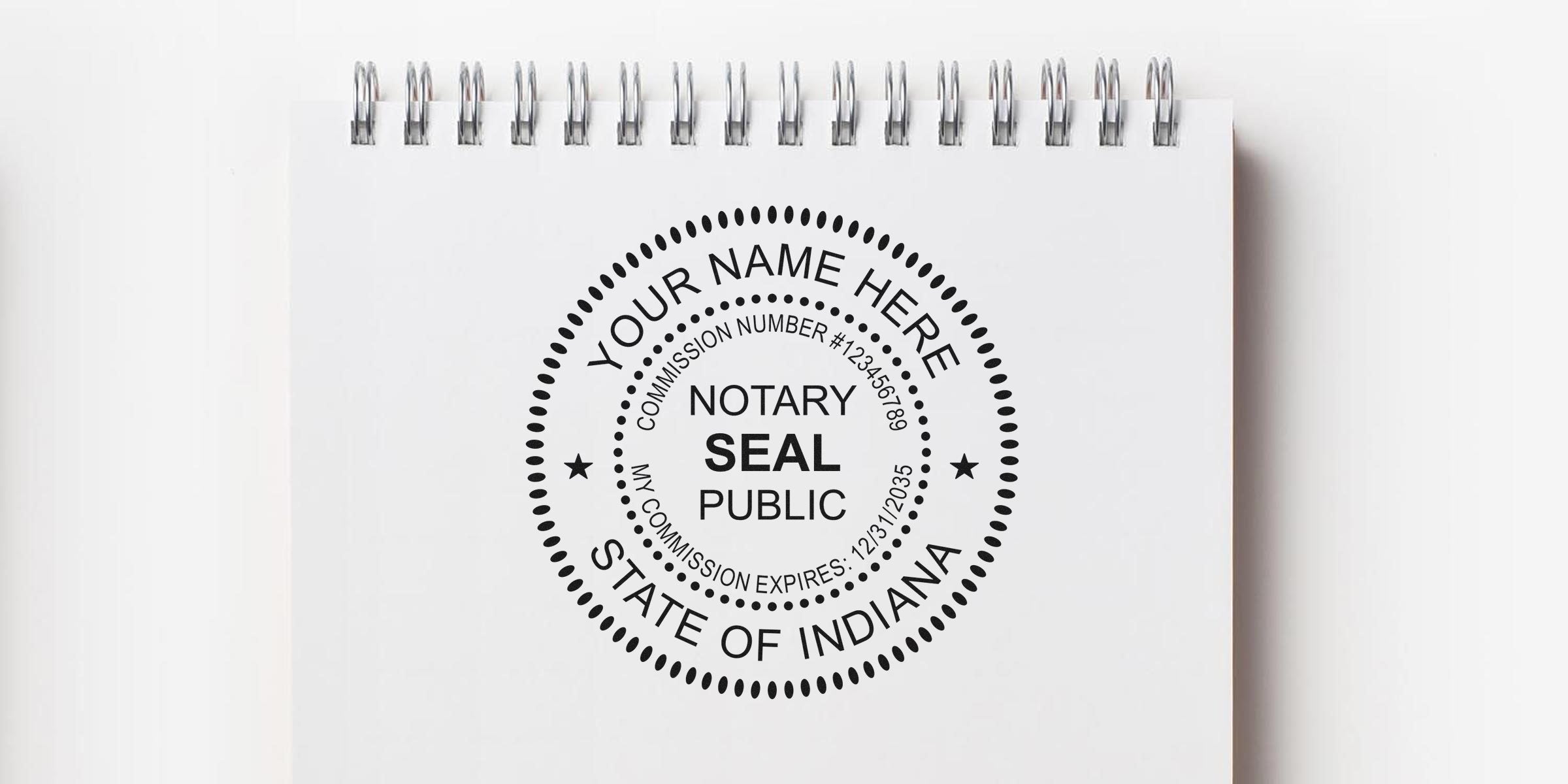 Indiana notary seal stamp with commission number and expiration date on a white spiral notebook, Indiana notary stamp.