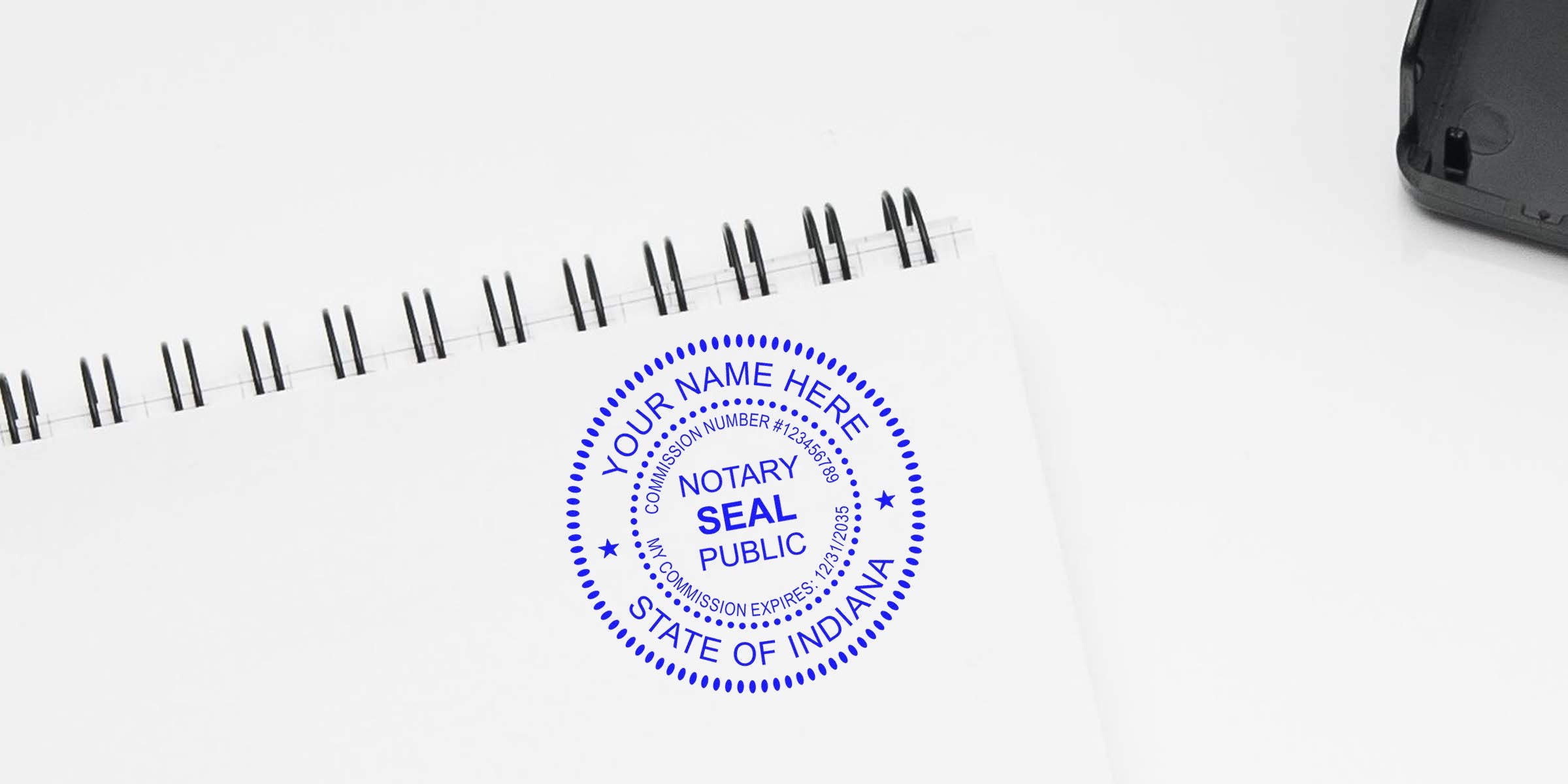 IN notary stamps on white spiral notebook for verifying Indiana notary requirements with official seal stamp.