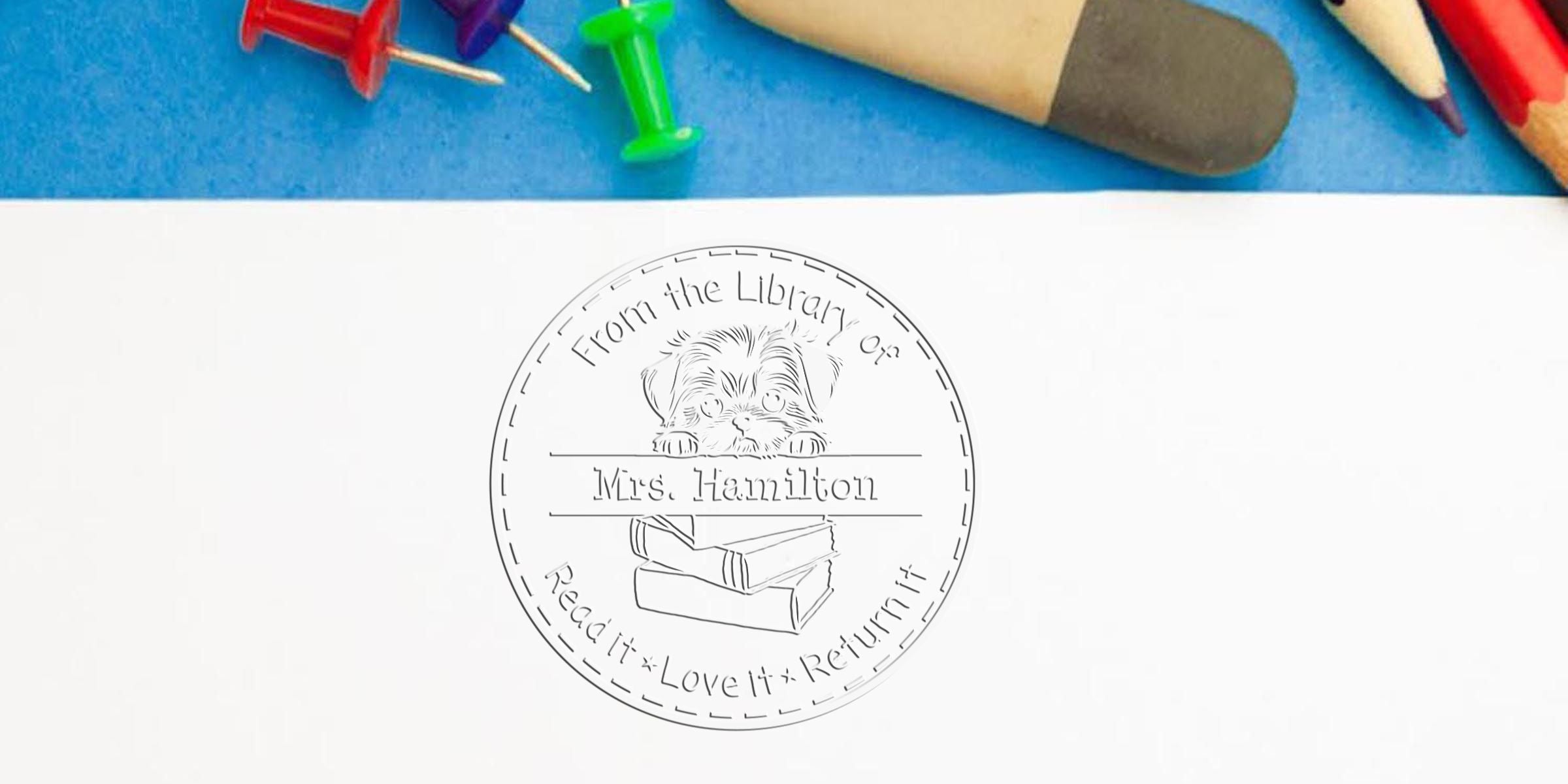 Children’s reading reward stamp with “From the Library of Mrs. Hamilton” and “Read it, Love it, Return it” text, featuring a puppy on books, with colored pencils and a pencil in the background
