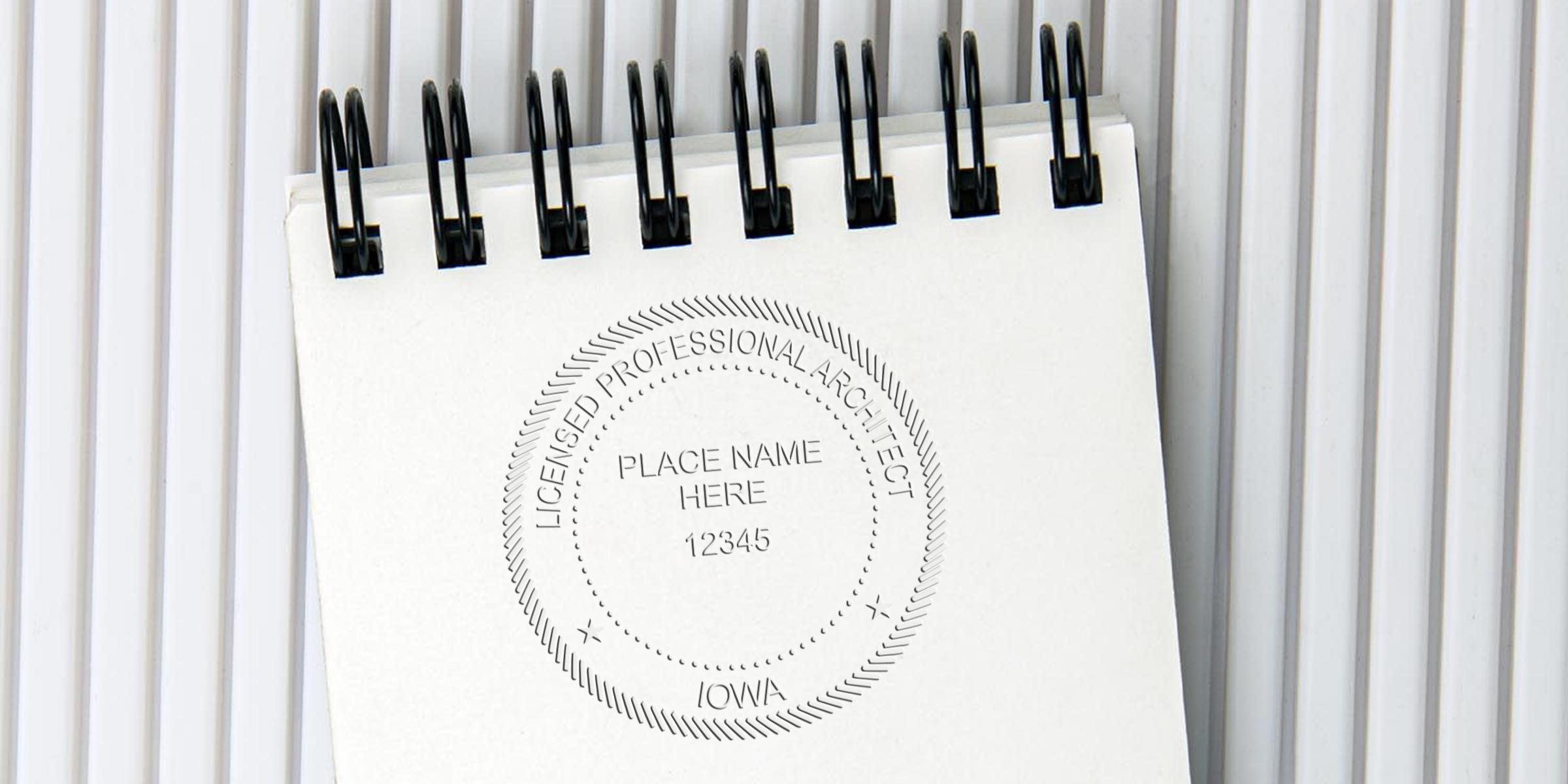 Licensed architect seal for Iowa on a spiral notebook, showing size and compliance with Iowa architect seal requirements.