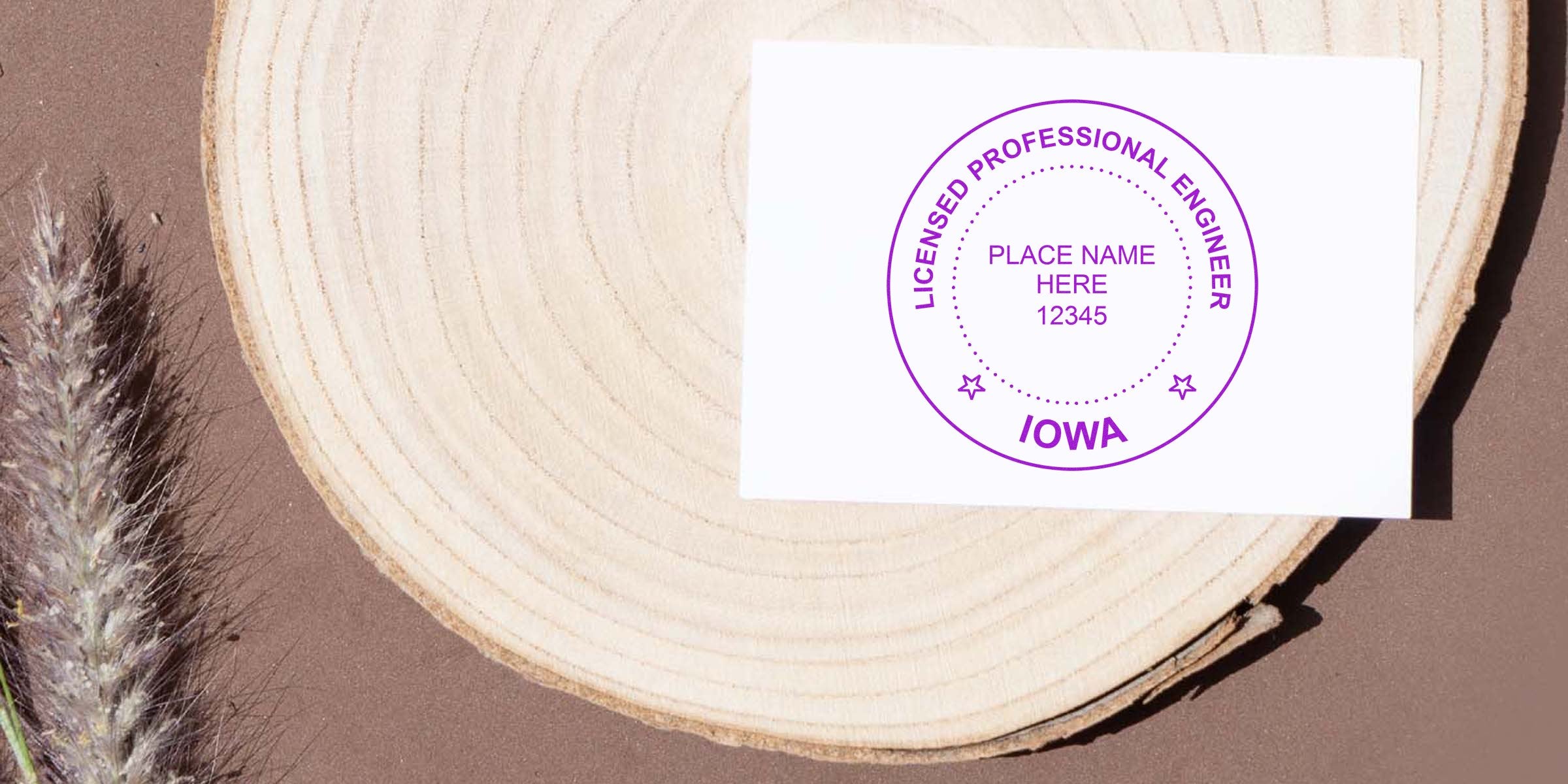 Iowa Professional Engineer Seal stamped on white card with Engineer Seal design, set on wooden surface with dried grass.