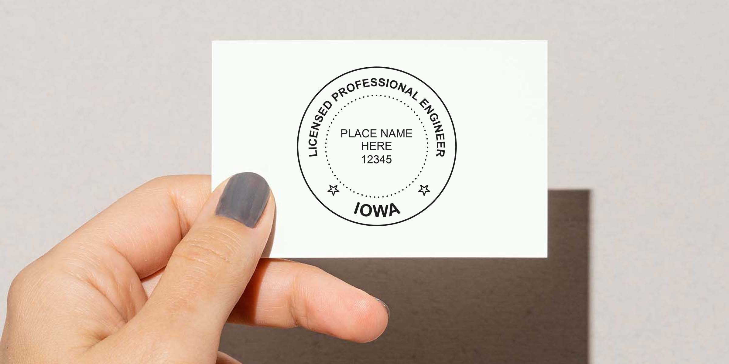 Hand holding Iowa PE stamp showing license number and location, demonstrating Iowa PE stamp size and specifications.