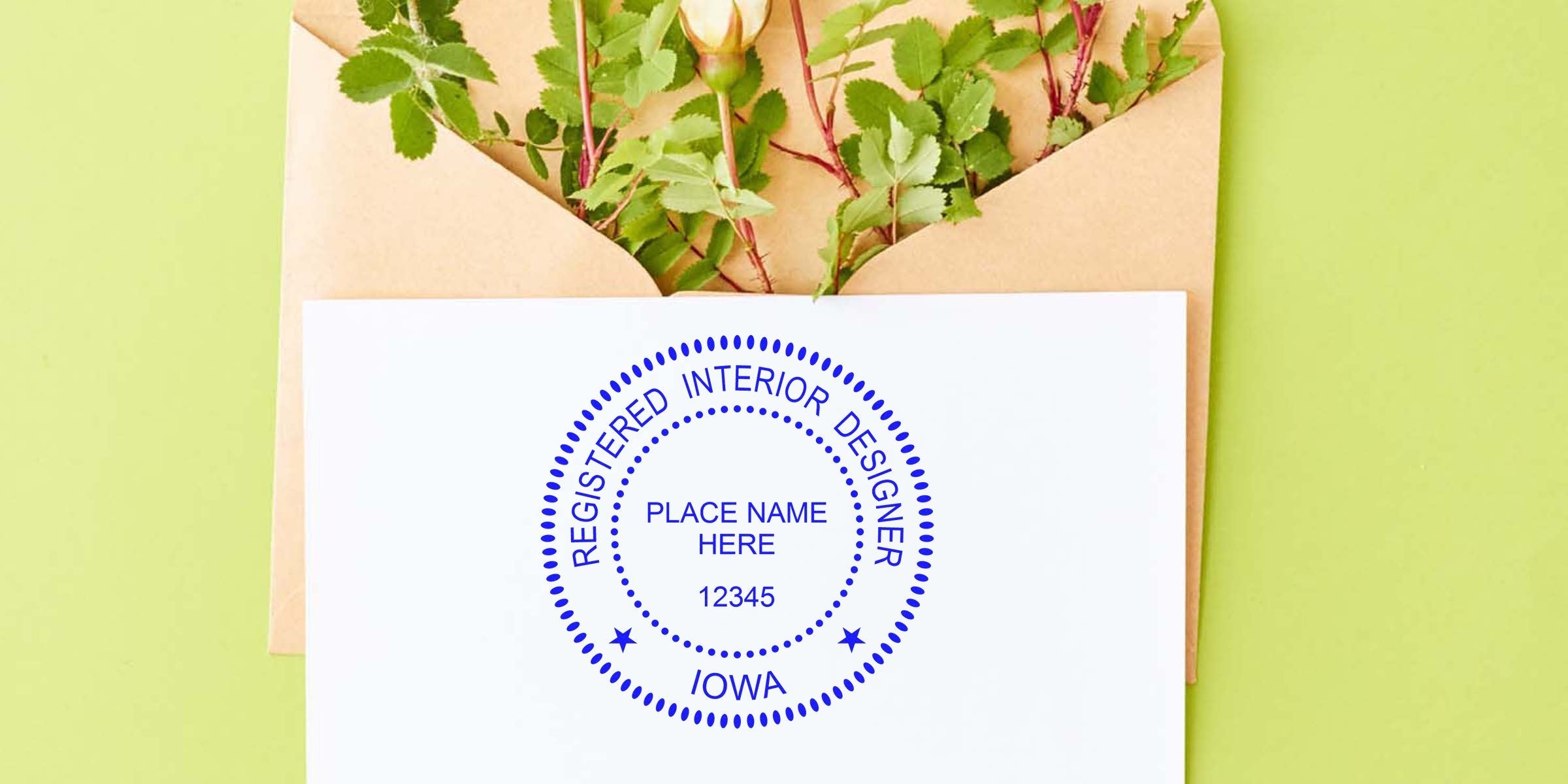 Iowa interior designer seal authentication stamp on white paper, accompanied by an envelope and green leaves background.