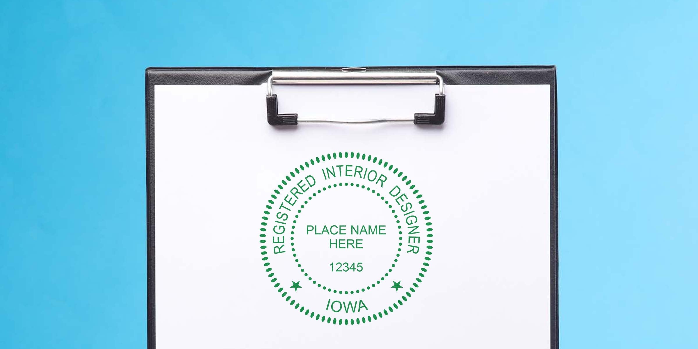 Registered interior designer stamp tools on clipboard with Iowa certification seal against a blue background.