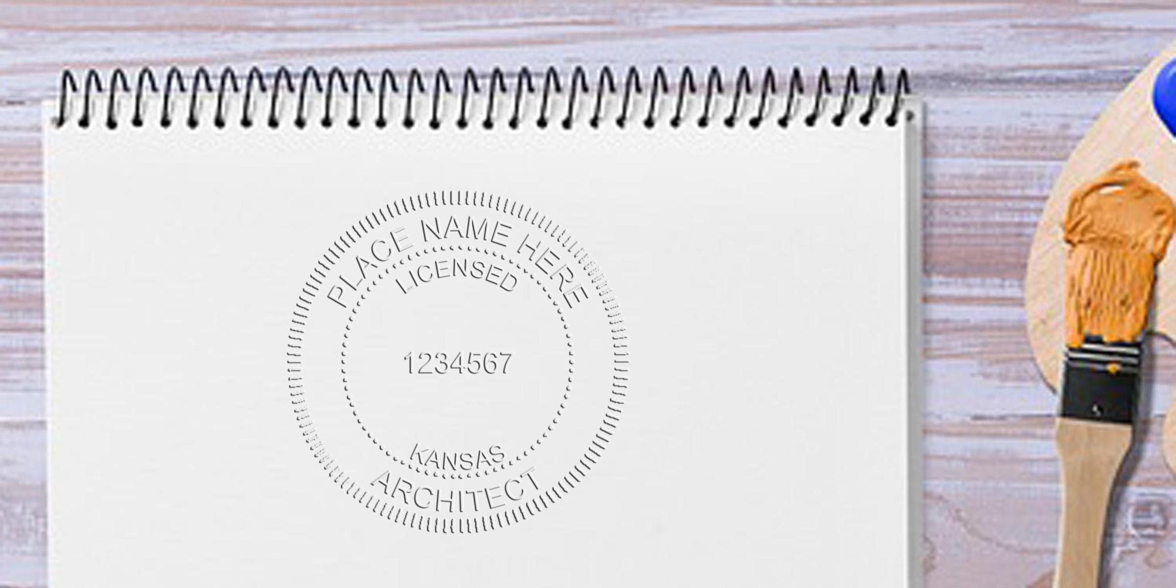Architect license stamp on blank notebook with paintbrush and palette on wooden table, illustrating Kansas architect stamp laws and requirements.