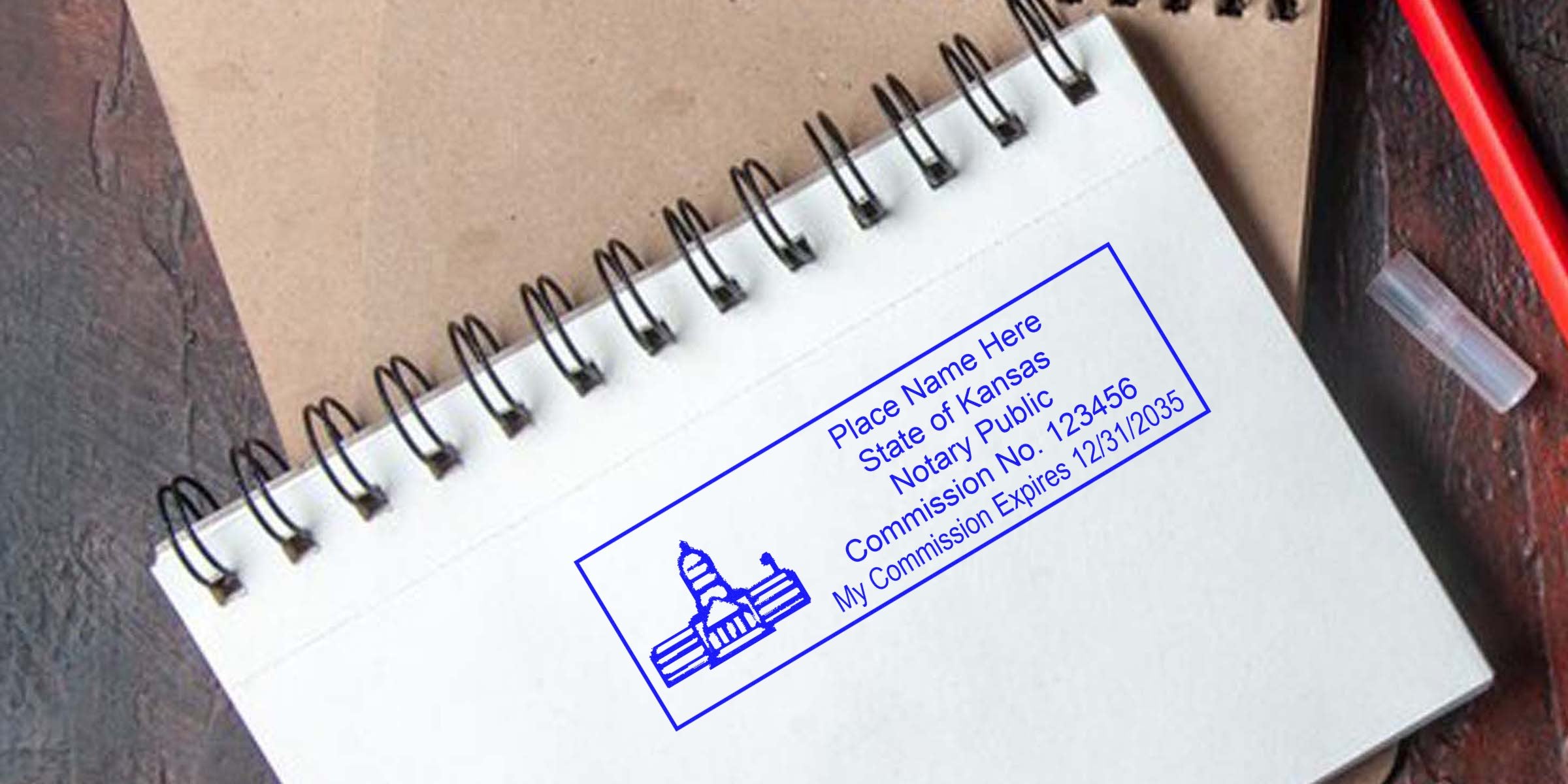 Kansas notary stamp with commission number and expiration date on a spiral notebook, featuring a Kansas notary public seal.