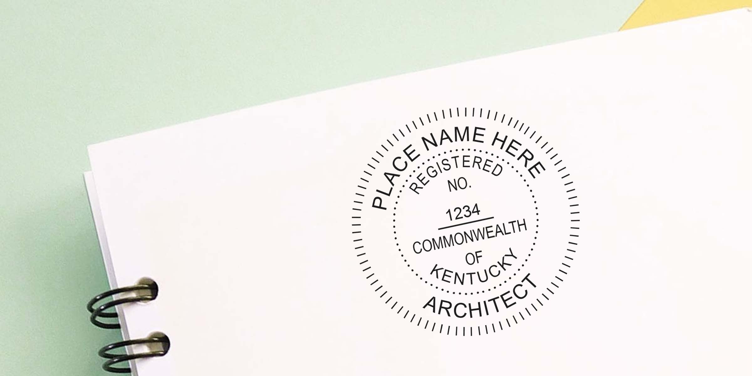 Kentucky architect seals stamped on a white spiral notebook, meeting the requirements for professional certification.