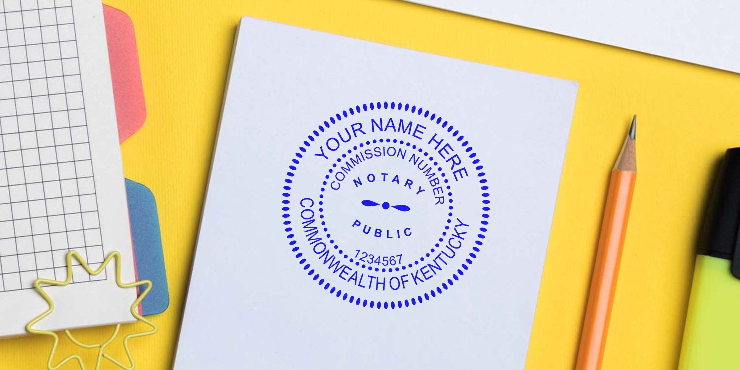 Kentucky notary seal stamp on white paper with pencil and highlighter on yellow background, showing notary seal purchase in Kentucky.
