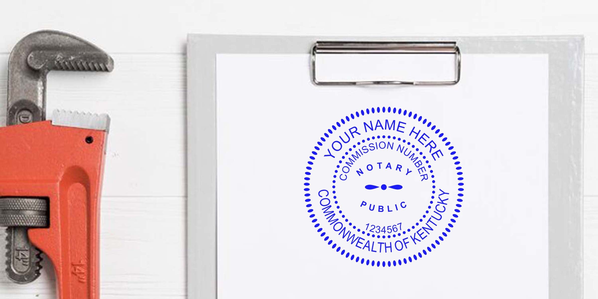 Custom Kentucky notary stamp on clipboard with pipe wrench on white wood background, showcasing Kentucky notary supplies and new essentials.