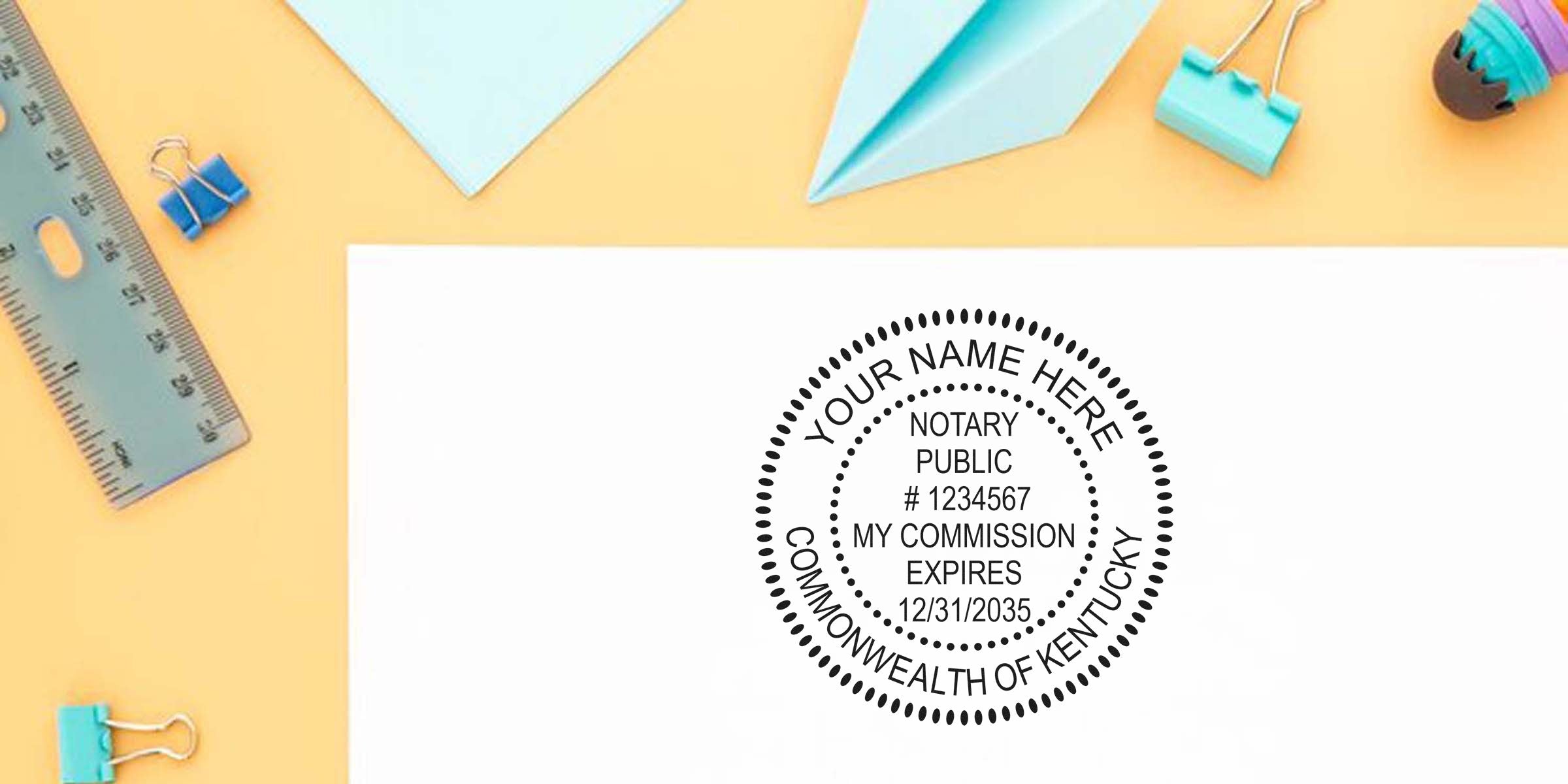 Top Kentucky notary stamp on white paper, set against a yellow background with office supplies around.