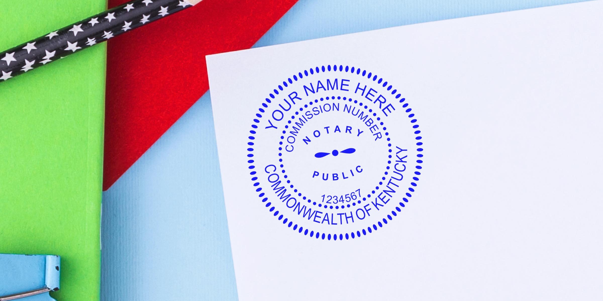 Kentucky notary stamp on white paper with colorful background, black star-patterned pencil, and Notary Kit Kentucky including Kentucky Notary Supplies.