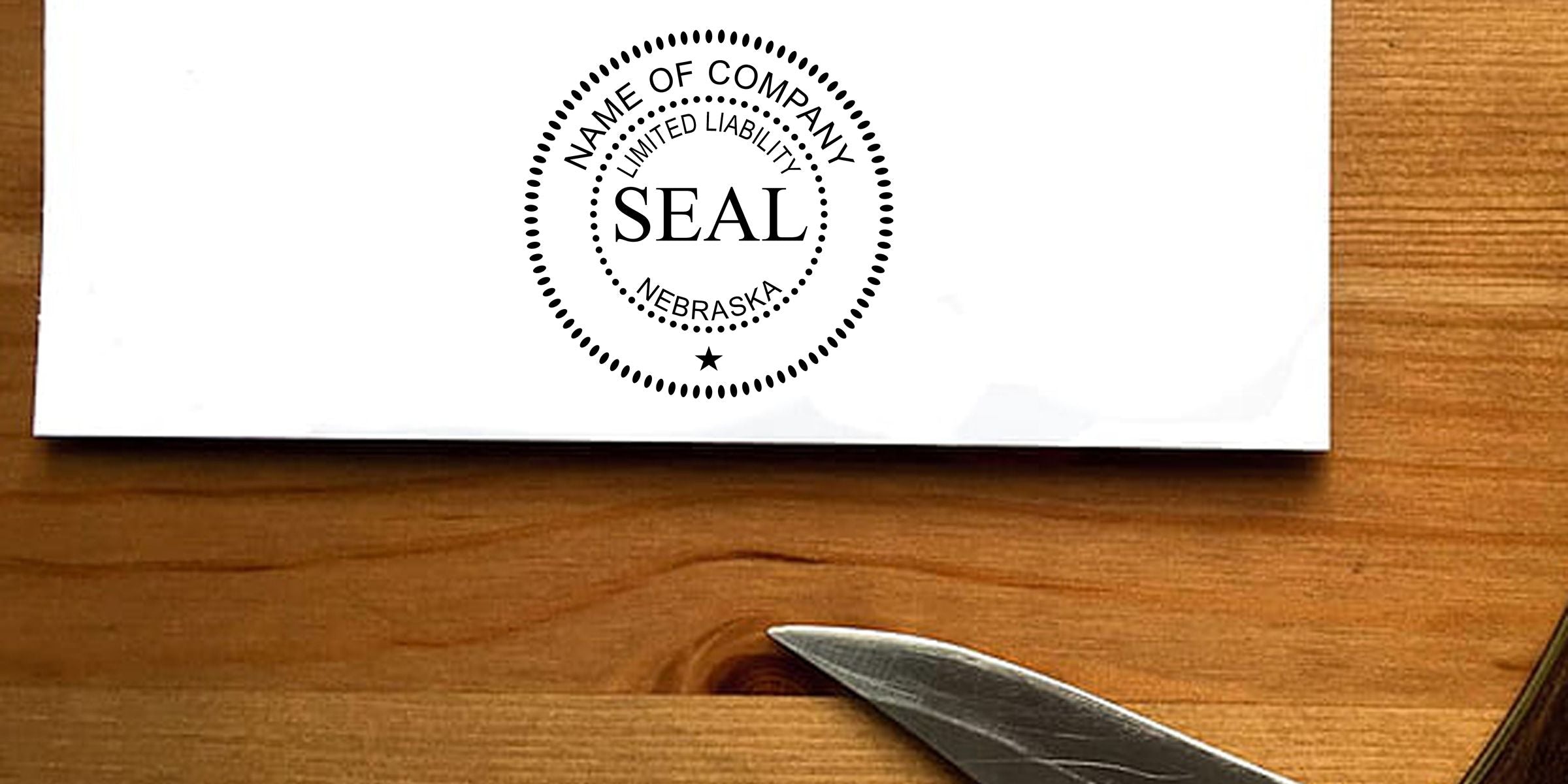 Nebraska limited liability company seal stamped on a business document on a wooden desk with a pen tip visible