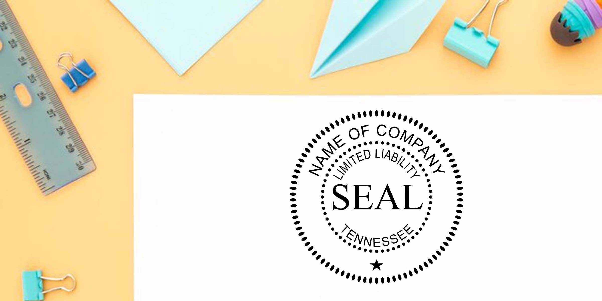 Tennessee limited liability company seal stamp on white paper surrounded by office supplies, ruler, binder clips, and paper airplanes on a yellow background