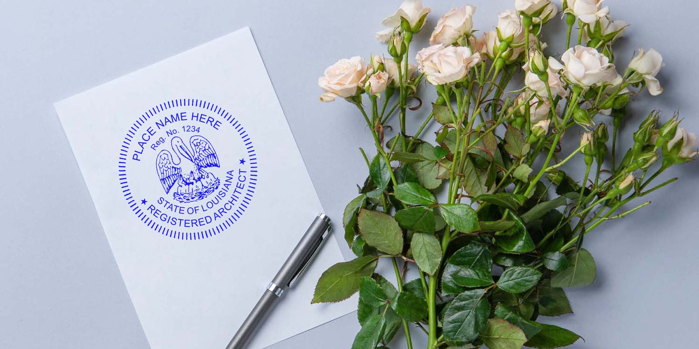 Louisiana architect seal embosser on white paper with silver pen and white rose bouquet on gray background, showcasing a professional architect seal.