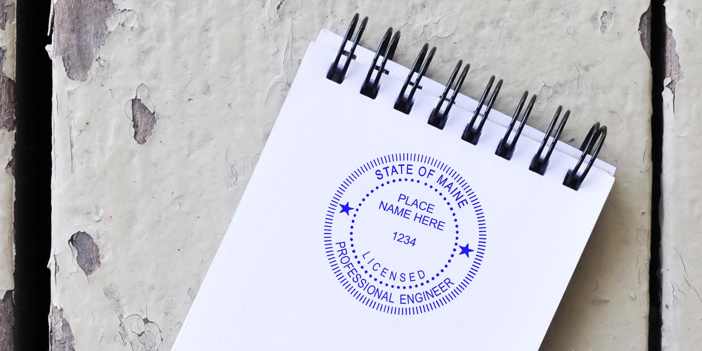 Licensed professional engineer seal on white spiral notebook, meeting Maine engineer stamp certification requirements.