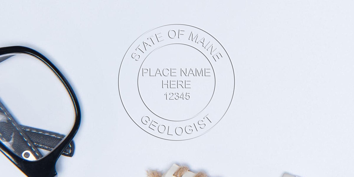 Maine Professional Geologist Seal embossed with a magnifying glass and geological tools, symbolizing certified geologists on a white background.