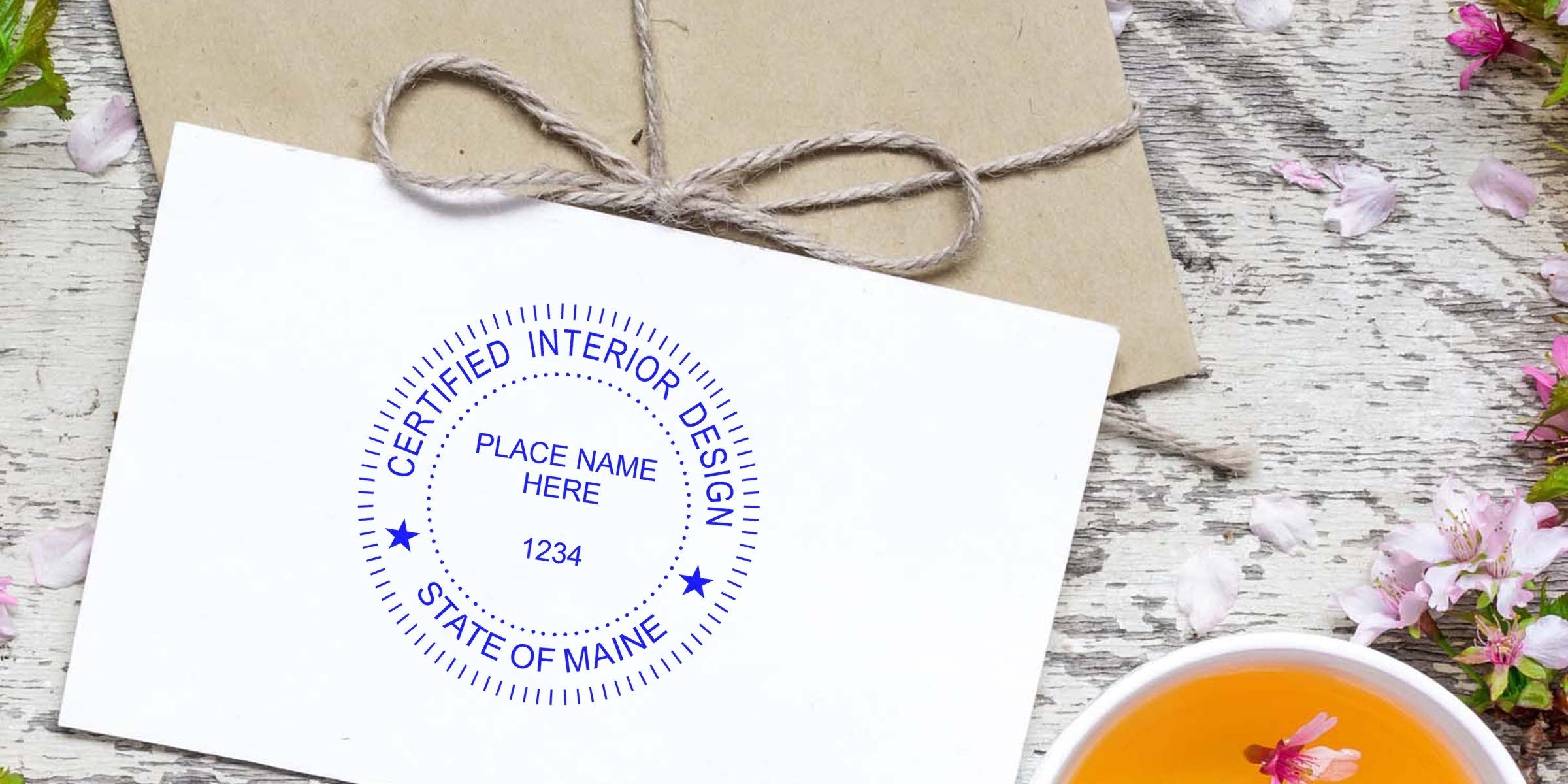 Certified interior design stamp on envelope with rustic wood background, tea cup, Maine design tools, designer stamps, and seals.
