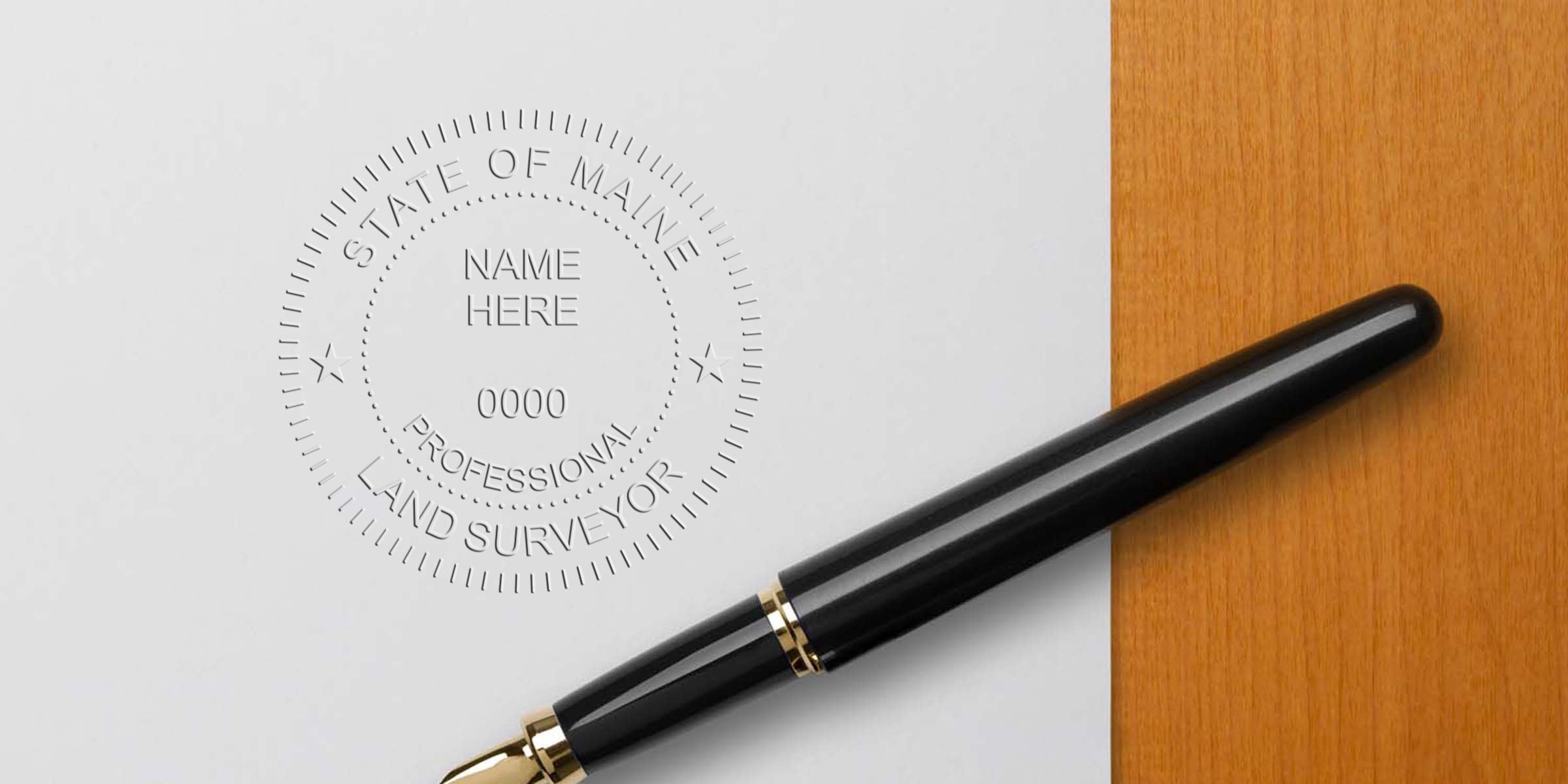 Maine land surveyor stamp embossed on paper with a black fountain pen, placed on a wooden surface, meeting the required surveyor stamp size.
