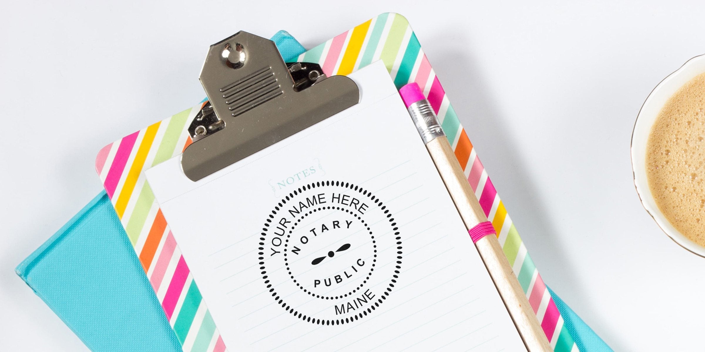 Maine notary public seal stamped on a clipboard with a colorful striped cover and pencil, highlighting Maine notary seal options.