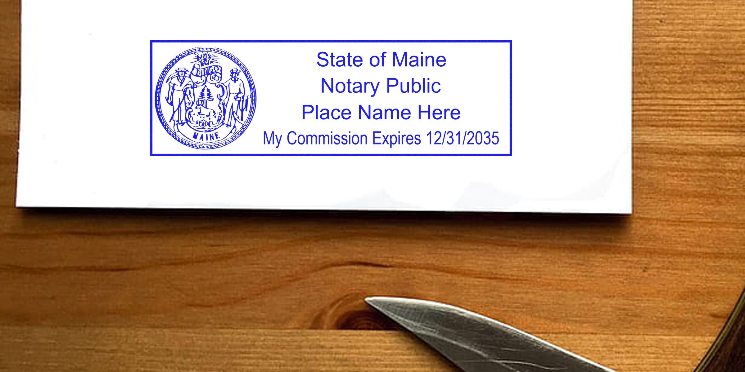 Maine notary stamp with official seal on white paper, set against a wooden background with a visible knife edge.