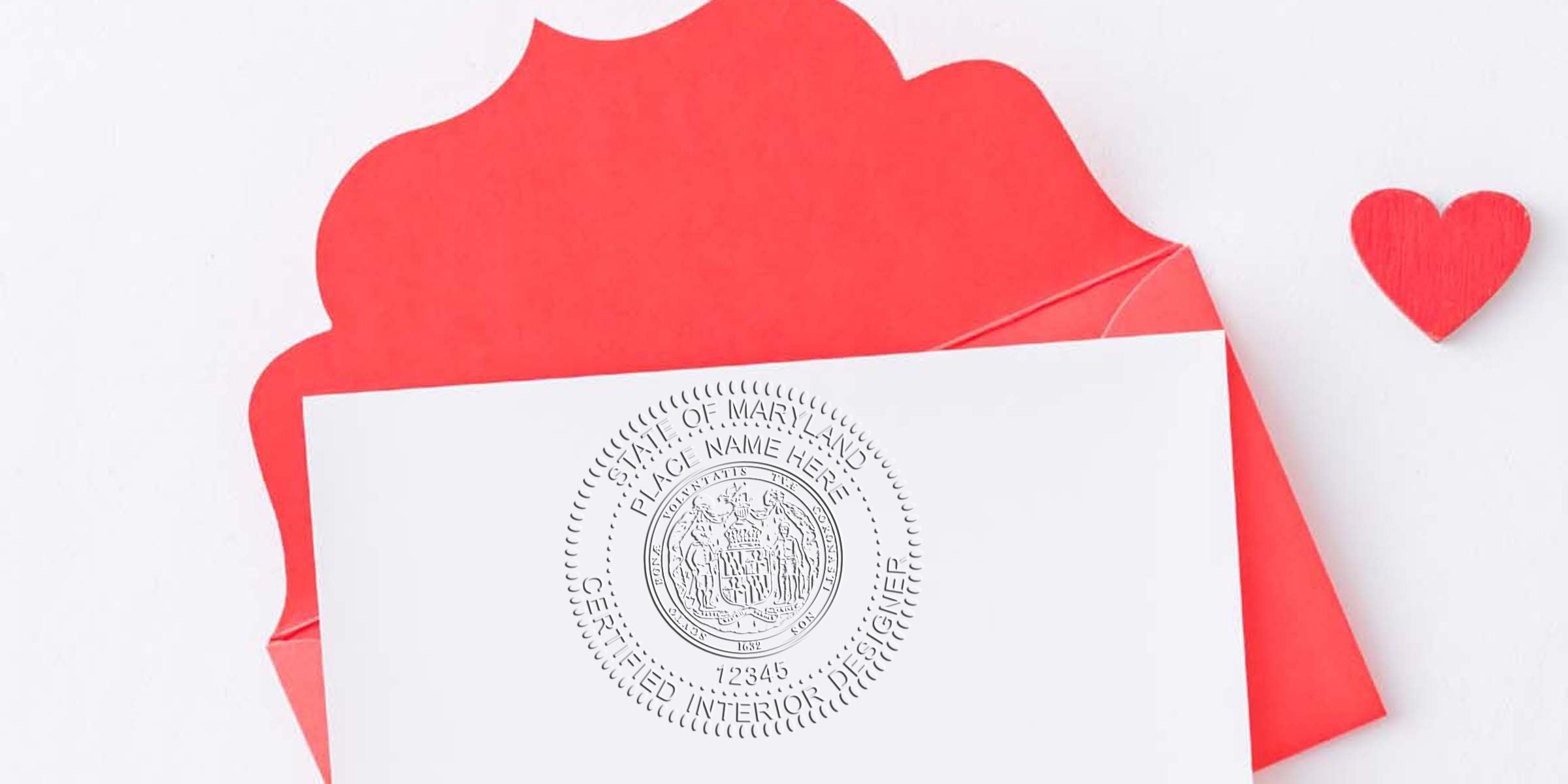 Red envelope with white card showing Maryland interior design certified seal, small red heart, and designer seal tools.