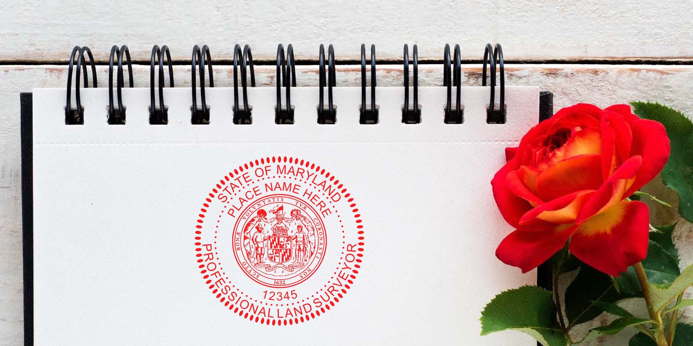 Maryland land surveyor stamp on notebook with red rose, displaying the Maryland professional land surveyor seal and stamp size requirements.