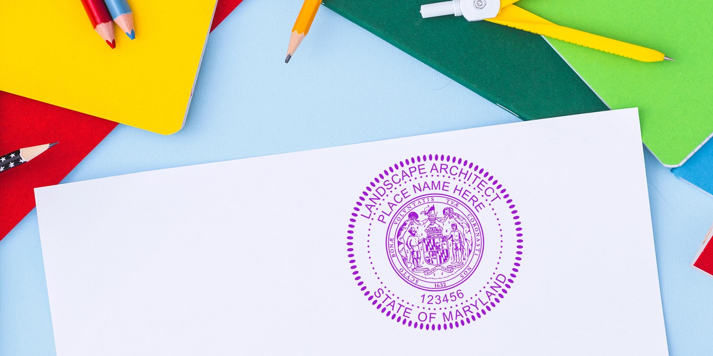 Maryland landscape architect seal on white paper, surrounded by colorful notebooks and pencils, emphasizing landscape architect compliance in Maryland.