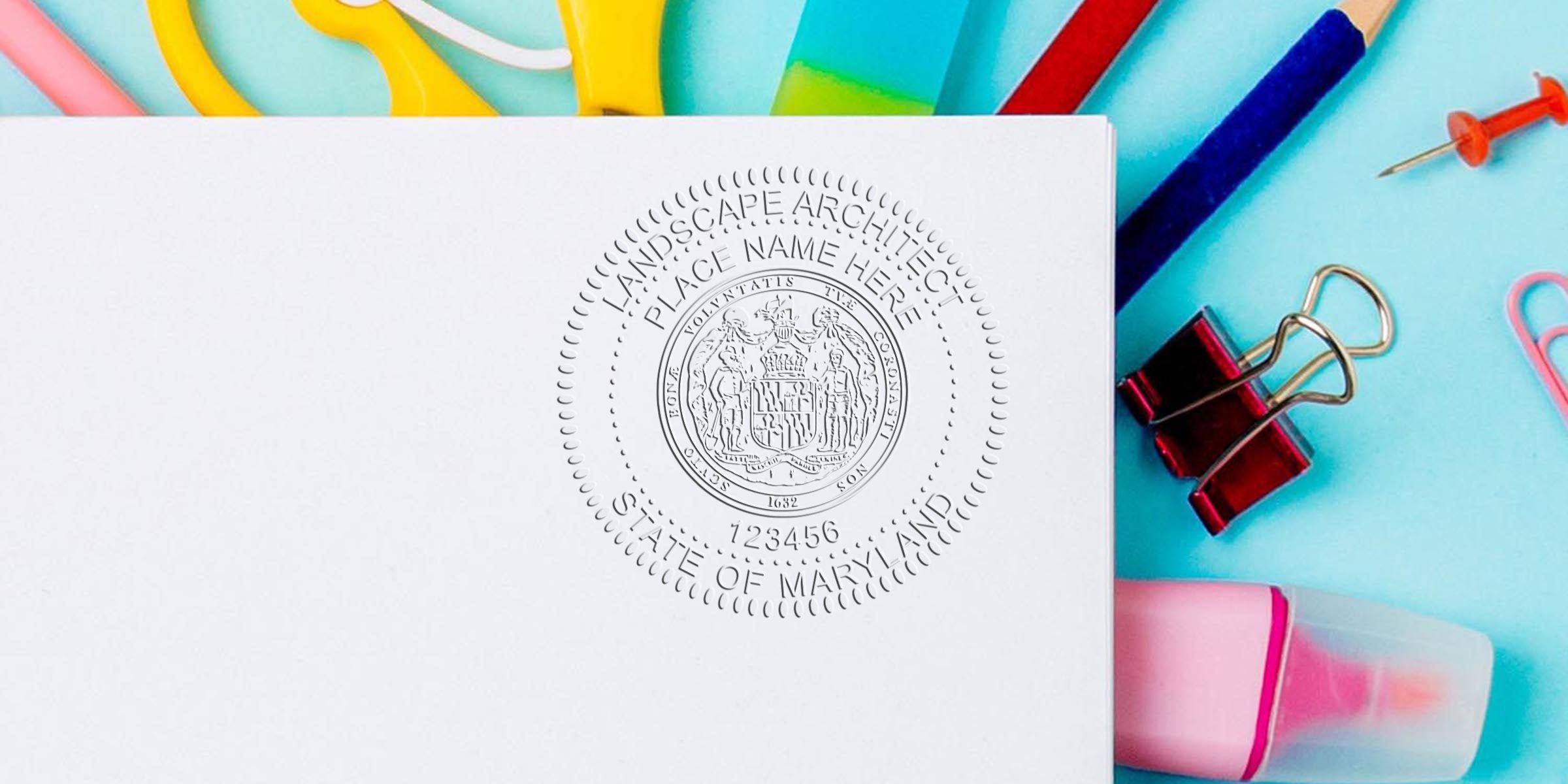 Maryland landscape architect seal embossed on white paper, surrounded by colorful office supplies like scissors, binder clip, and eraser, symbolizing landscape project certification.