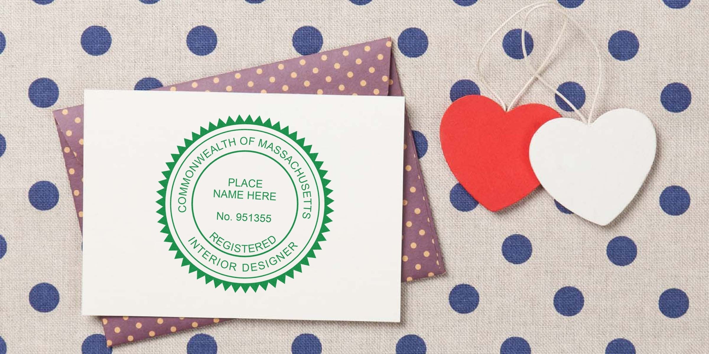 Commonwealth of Massachusetts interior designer stamp on white card with purple polka dot envelope and red-white heart fabric decorations, showing the stamp purchase process.