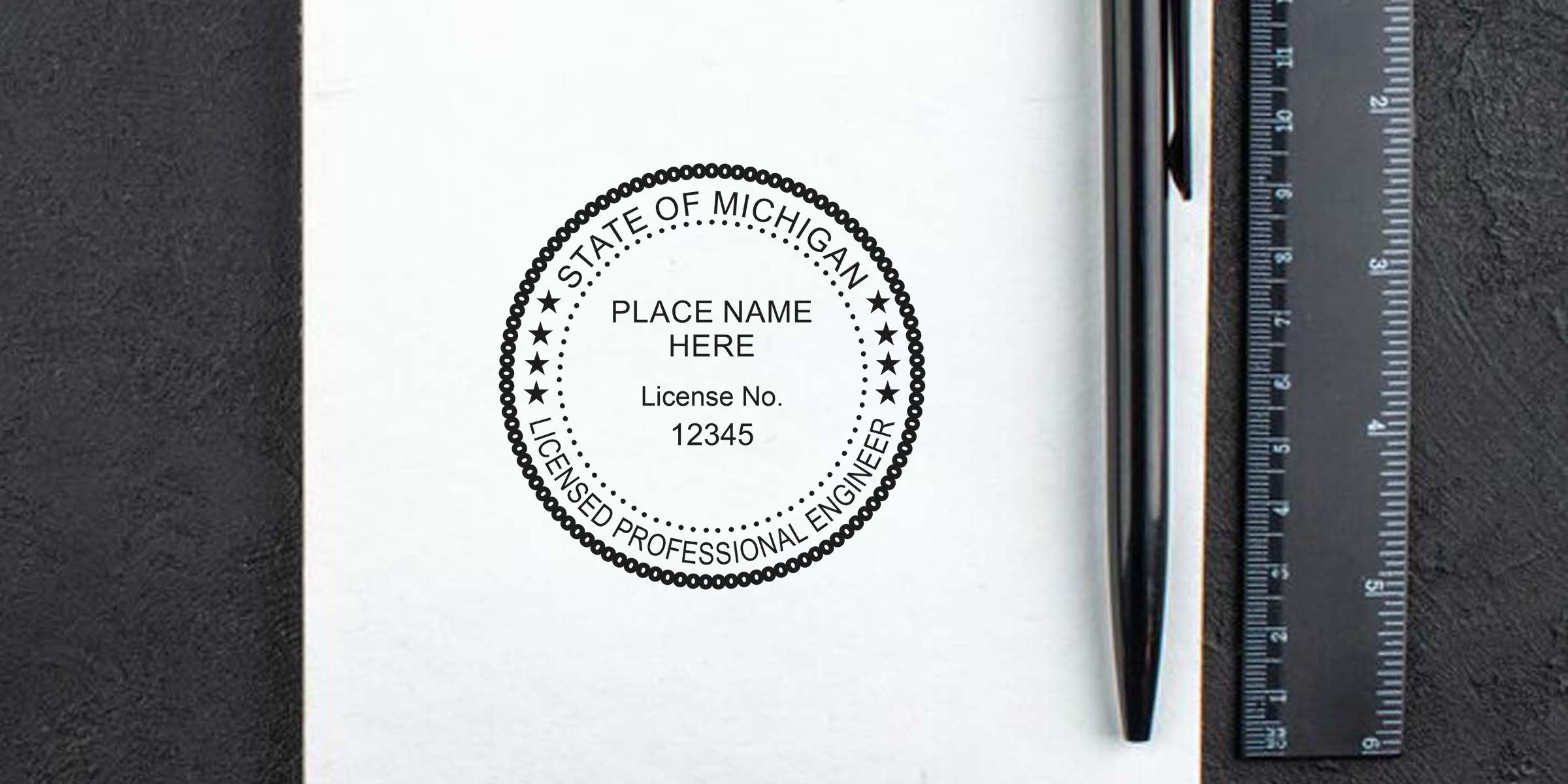 Michigan licensed professional engineer stamp on white paper with pen and ruler, displaying stamp size and dimensions.