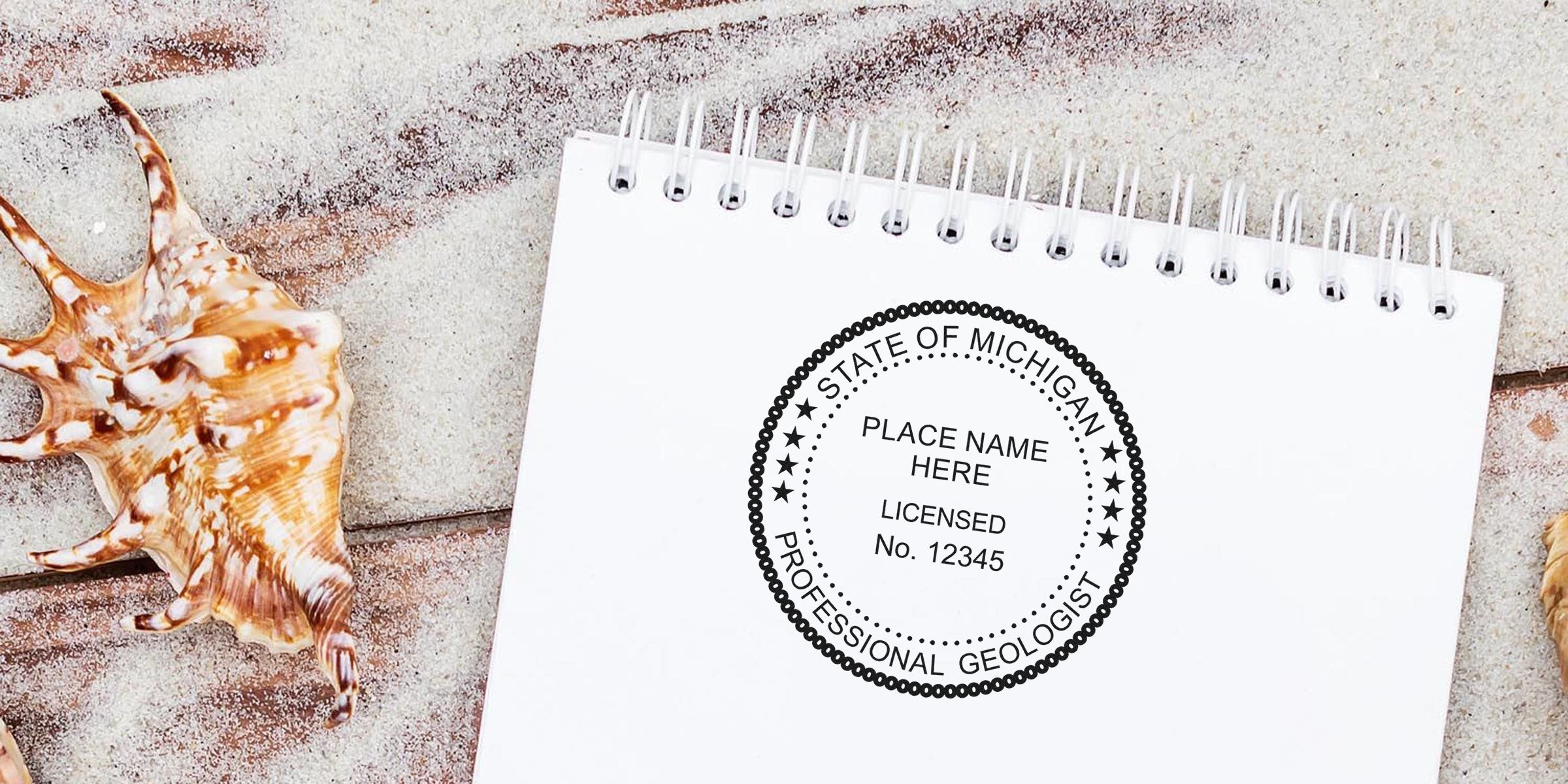 Notepad on sandy beach with seashells, featuring Michigan geologist seal and custom stamp for licensed professional geologist certification.