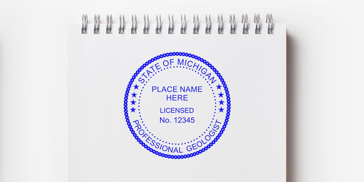 Michigan Geologist Stamp with location and license number on a white spiral notebook, linked to Geologist Stamp Application.
