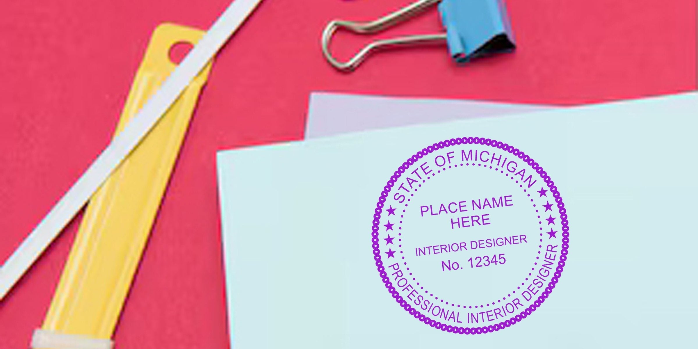 Stamp design benefits displayed on paper with the State of Michigan interior designer seal and office supplies.