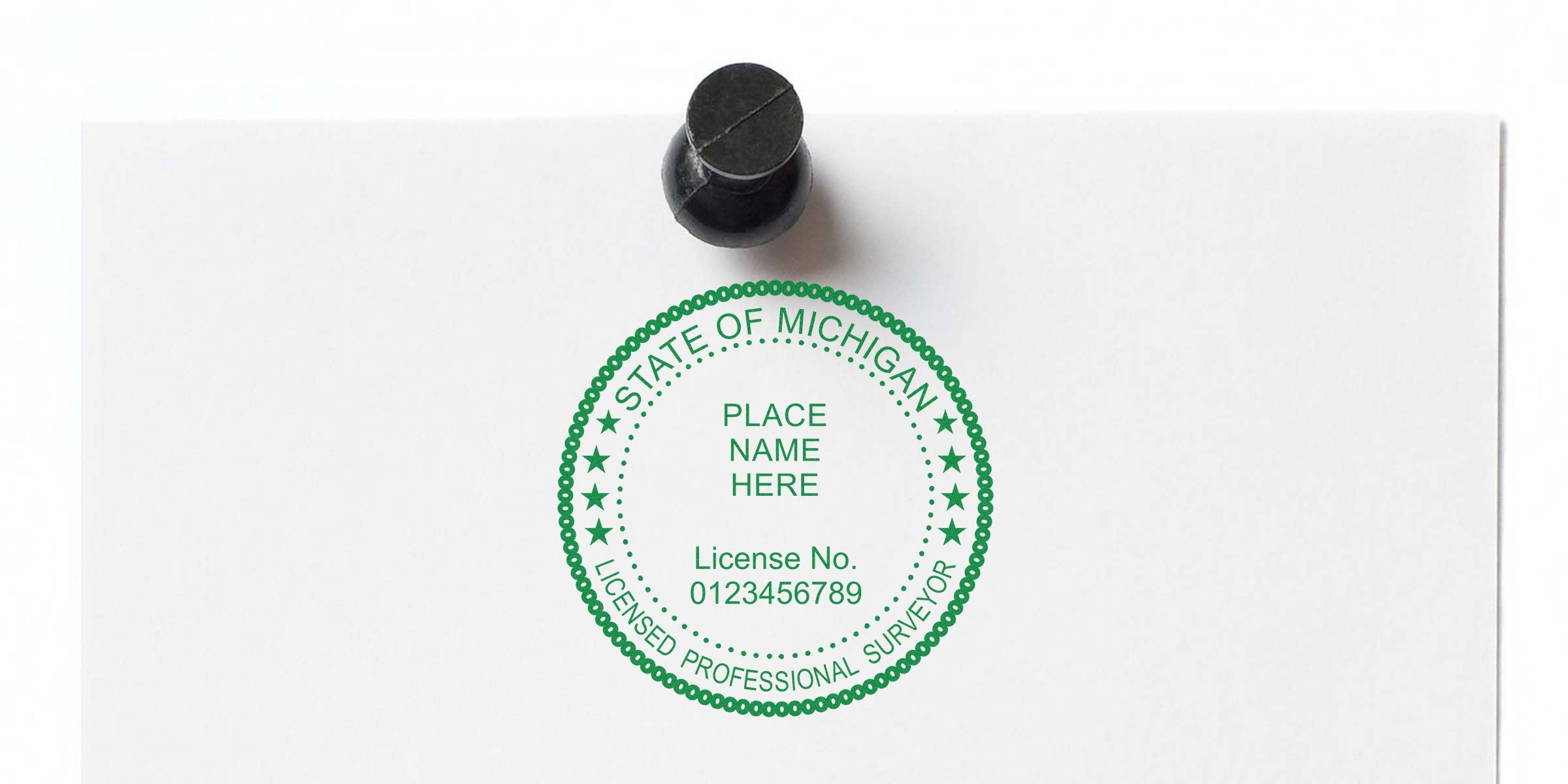 Michigan surveyor stamp with license number on white paper, pinned by black pushpin, meeting state surveyor stamp requirements.