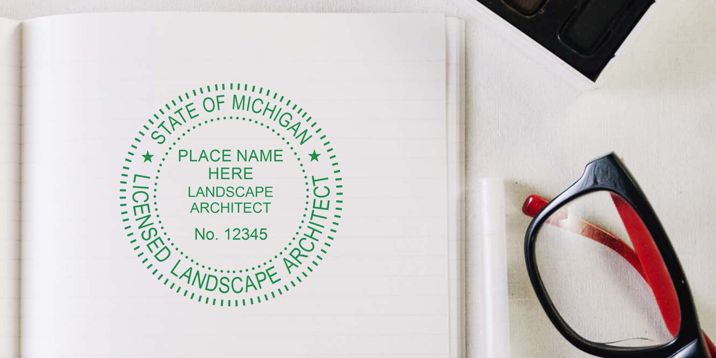 Michigan landscape architect stamp on notebook with glasses and pen, highlighting stamp design requirements.