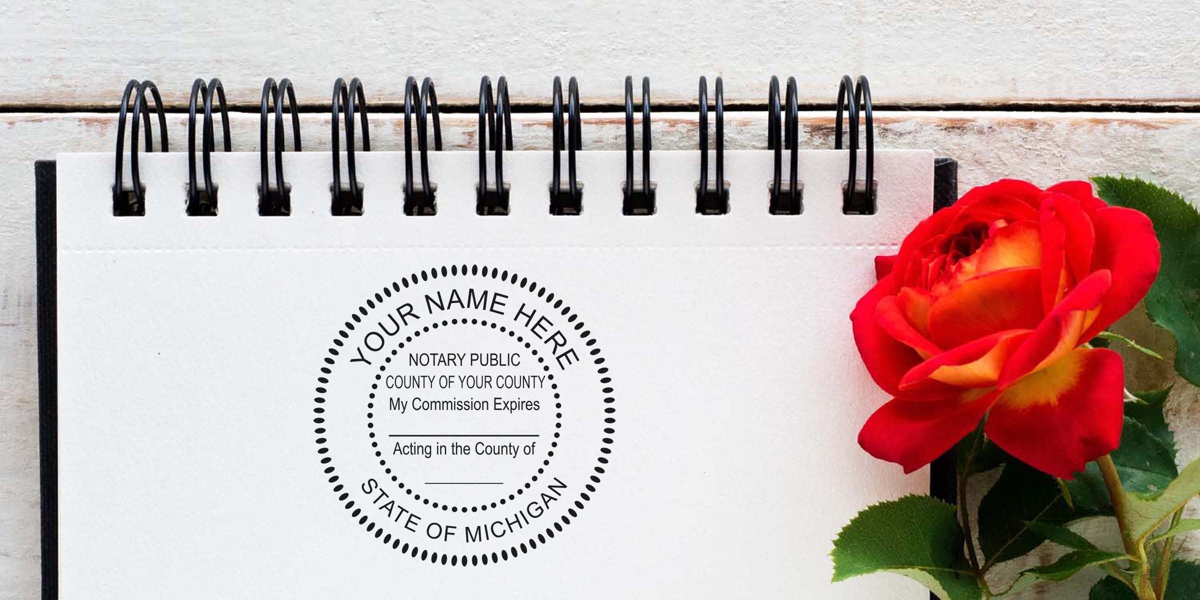 Michigan notary seal stamped on spiral notebook with red rose on wooden table, showing Michigan notary seal requirements.