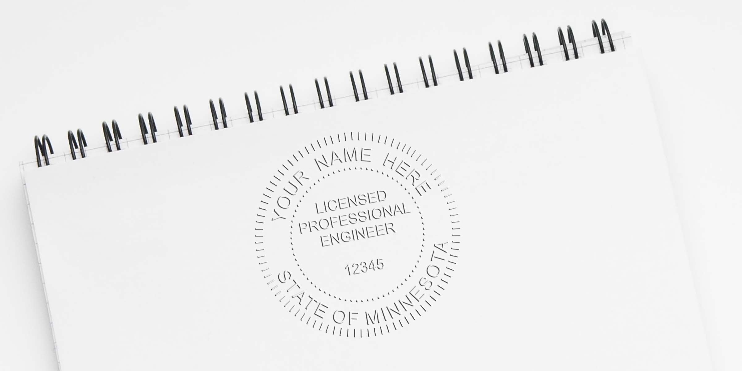 Custom Minnesota engineer stamps with licensed professional engineer seal on a white spiral notebook for engineering certification.