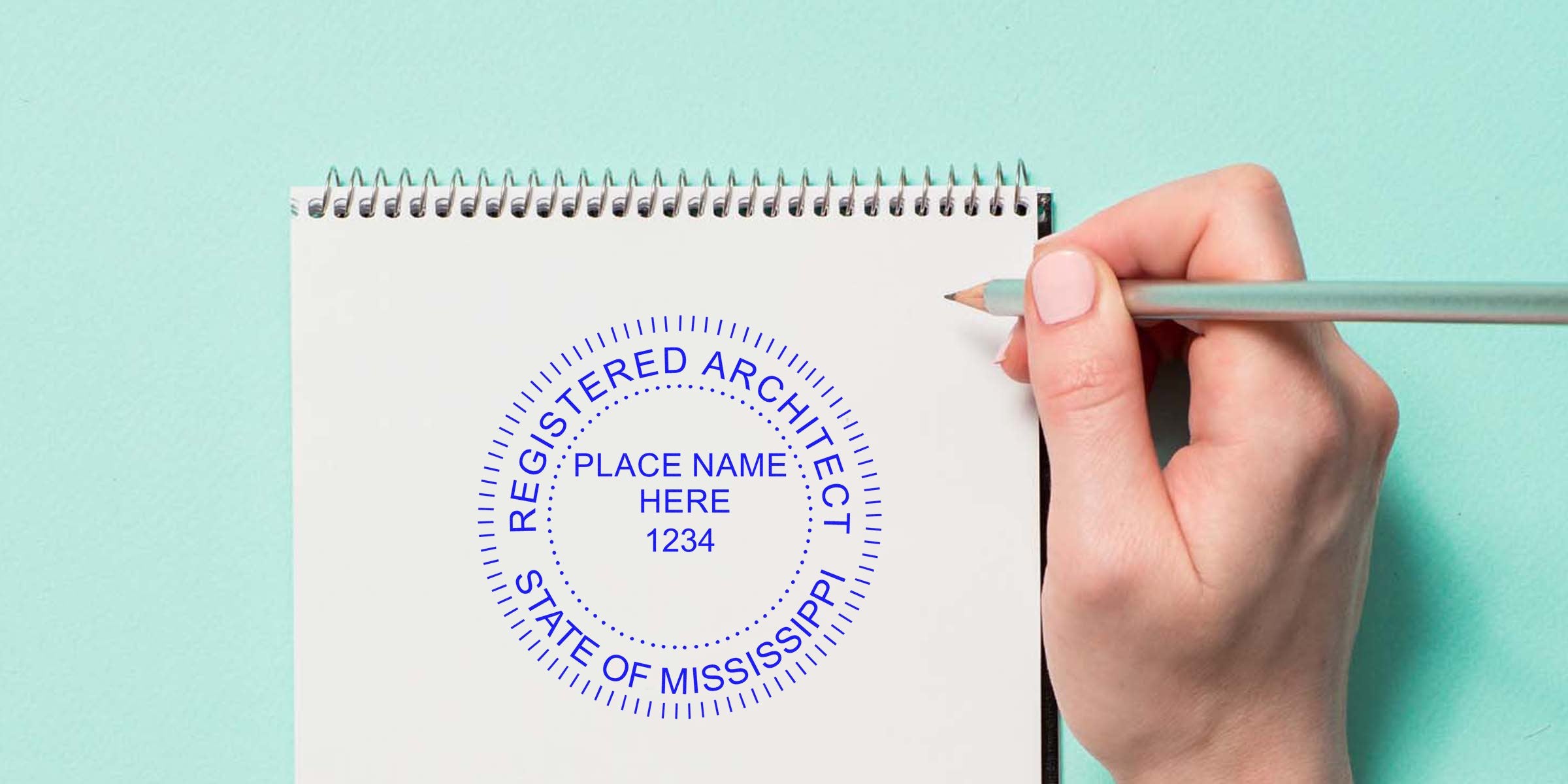 Hand holding pencil over notebook with Mississippi architect stamp for license verification, meeting architect stamp regulations.