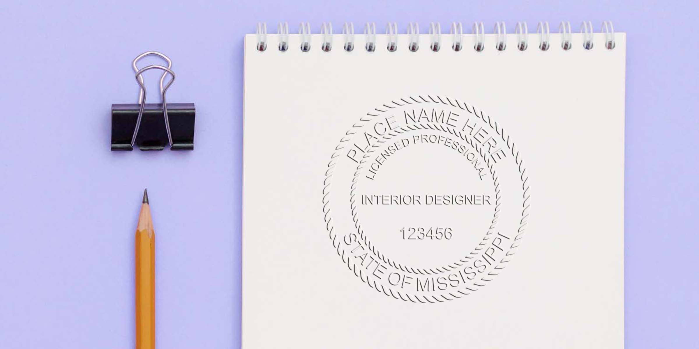 Mississippi interior design license seal on white notepad with pencil and binder clip, set against a purple background, showcasing seal design tips.