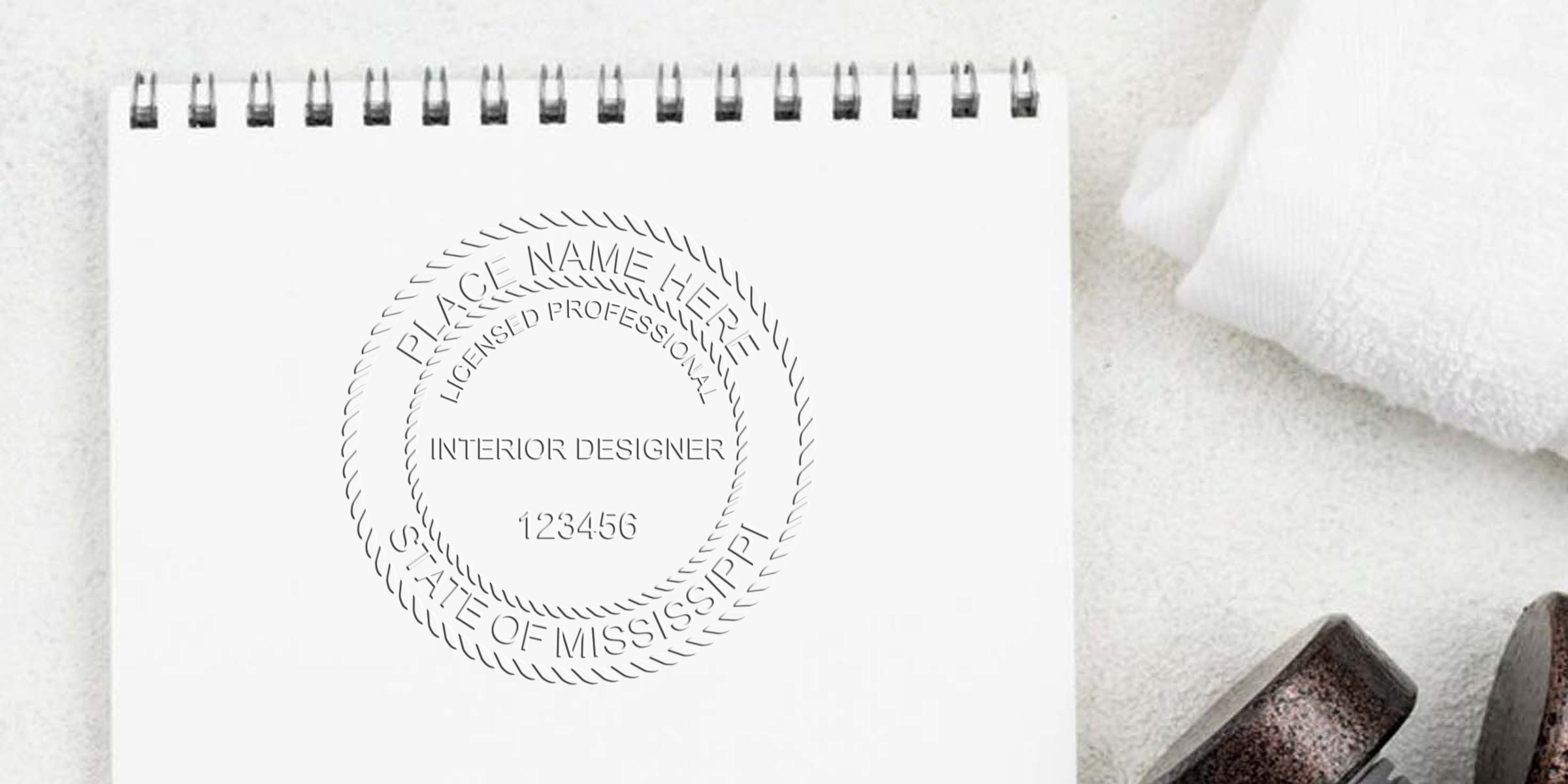 Mississippi interior designer seal on white notepad with towel and spa stones, showcasing the benefits of interior design certification.